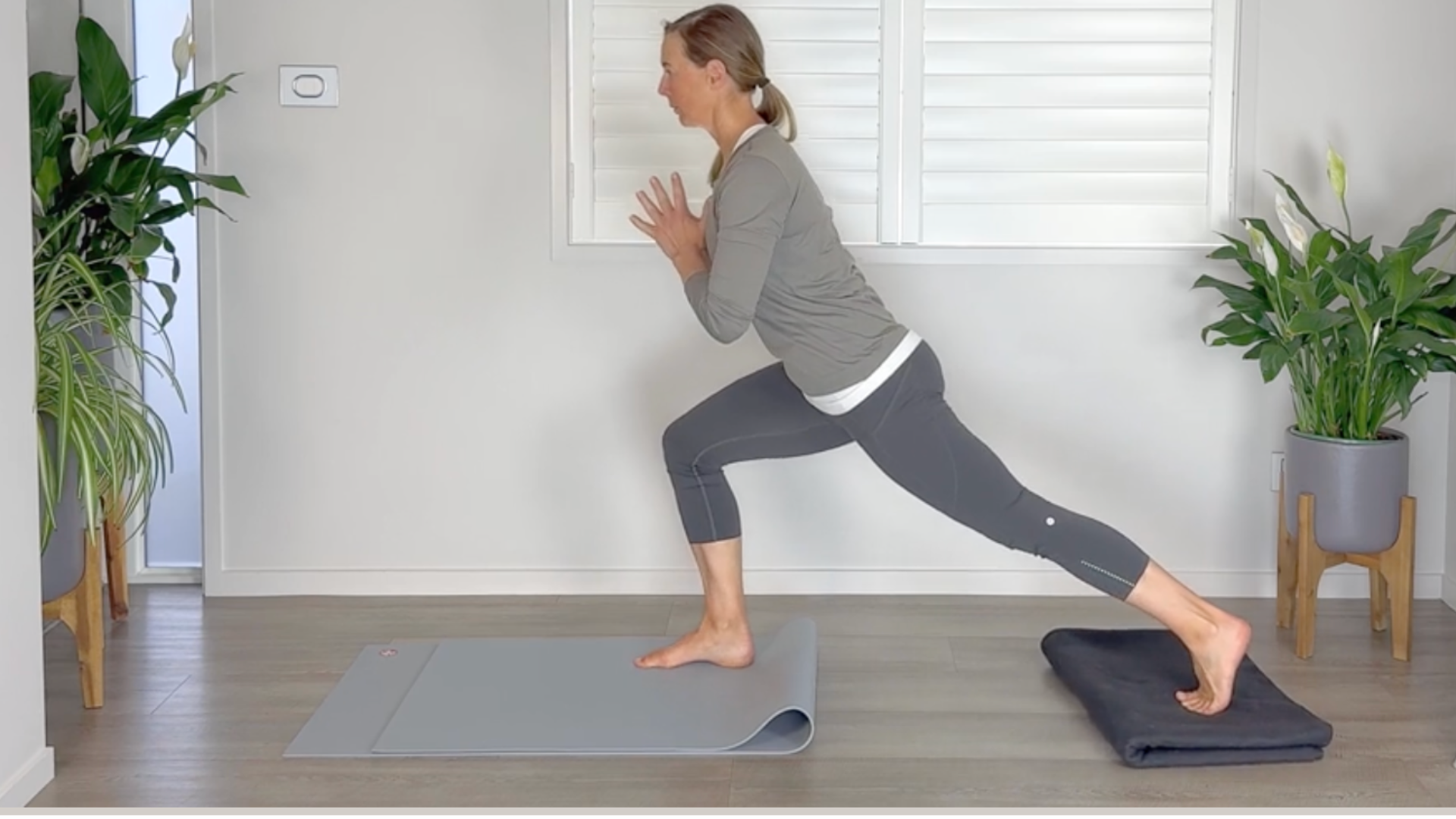 A woman slides her back foot behind her in a high lunge