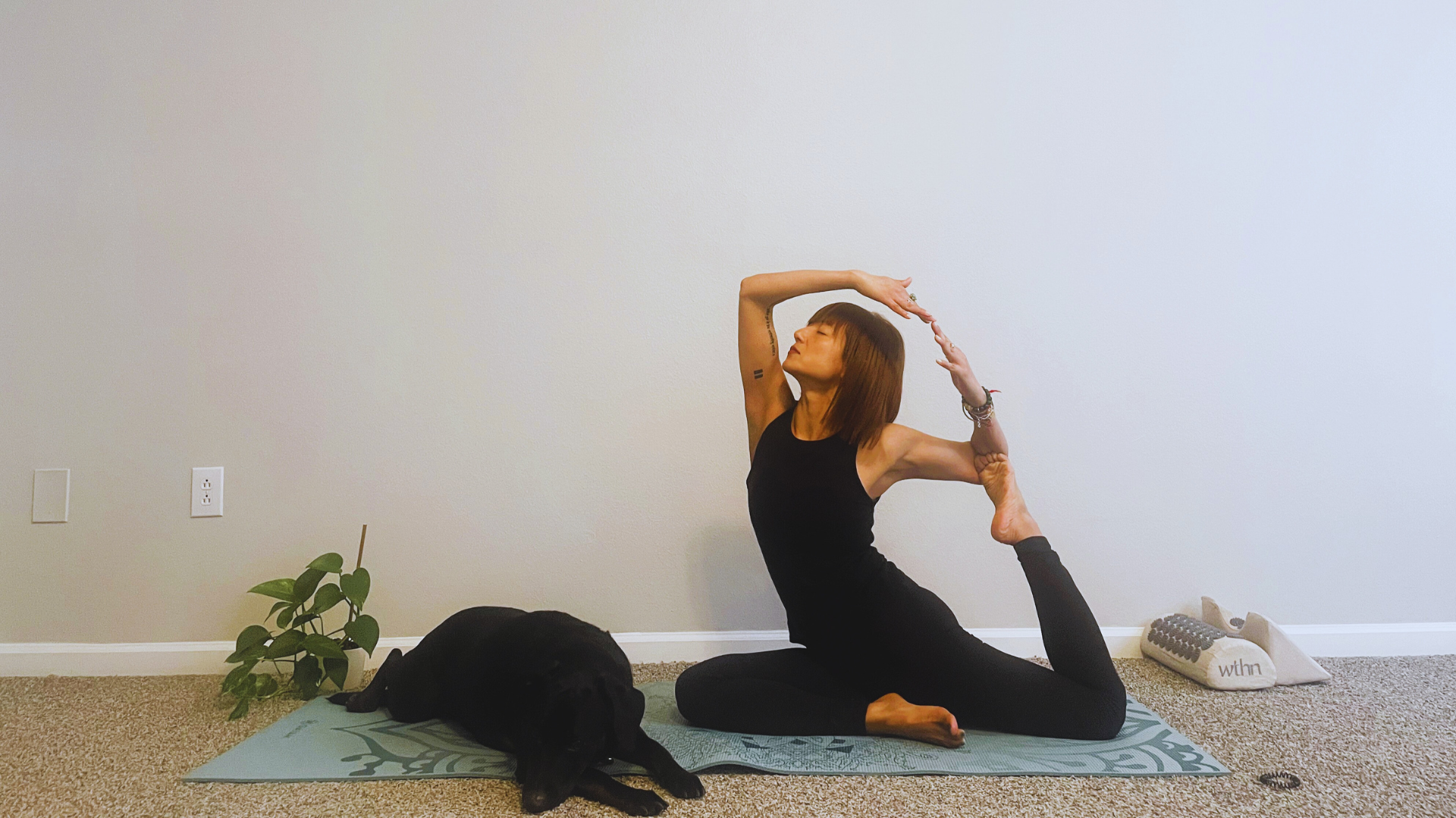 Woman on a yoga mat practicing the backbending variation of Pigeon Pose
