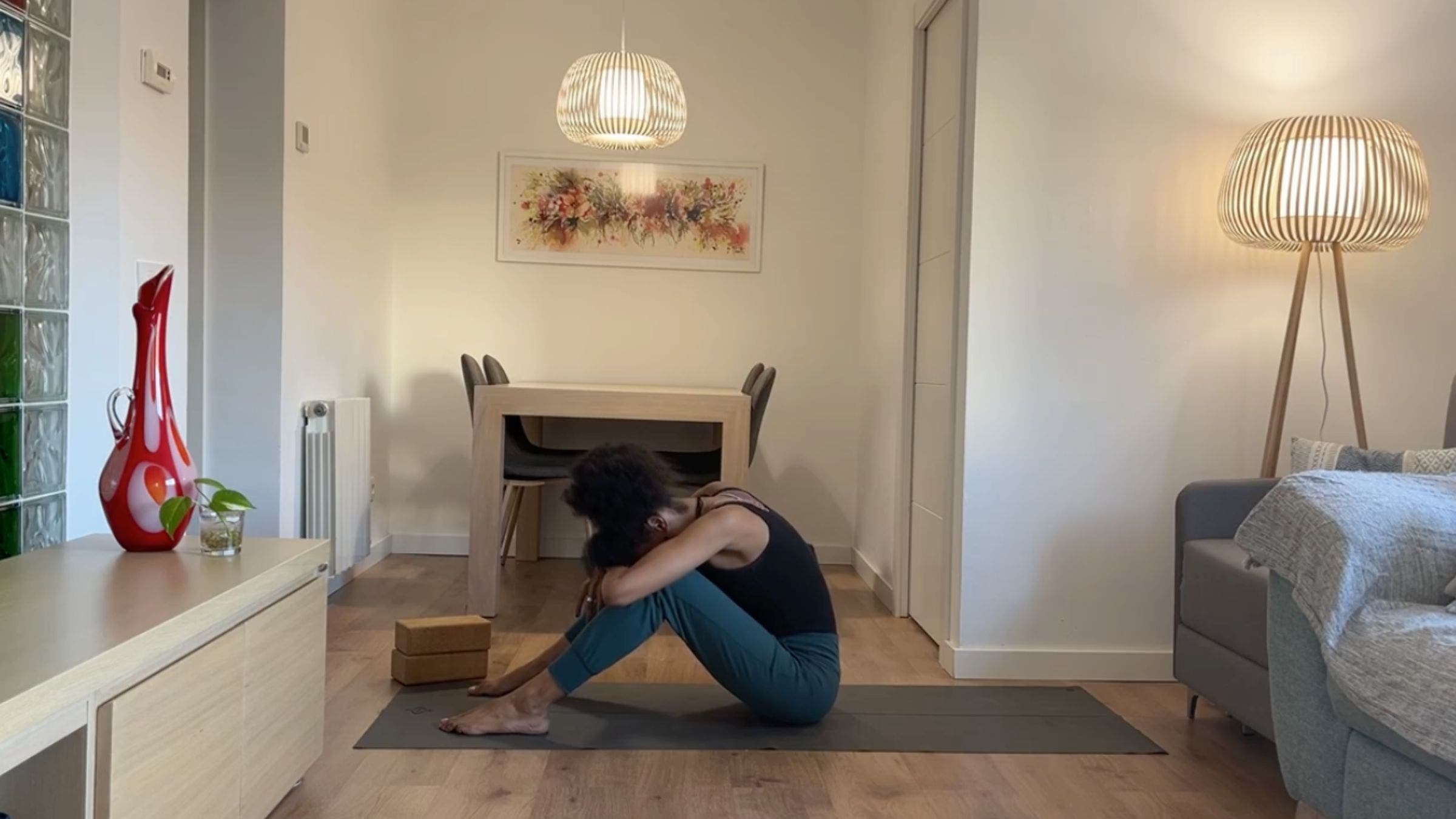 Yoga instructor practicing rounded seated stretch.