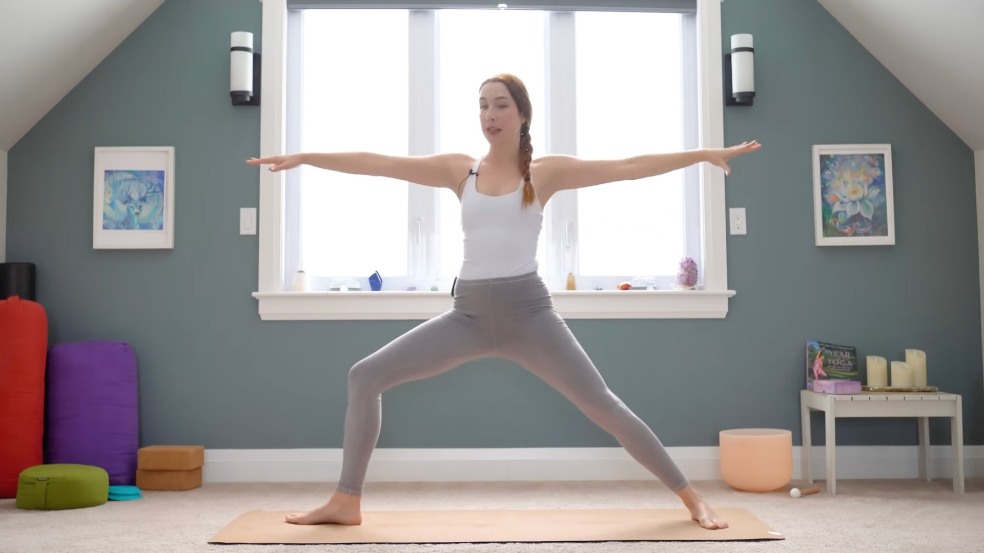 Woman standing on a mat in Warrior 2 Pose during a 15-minute yoga for upper back class