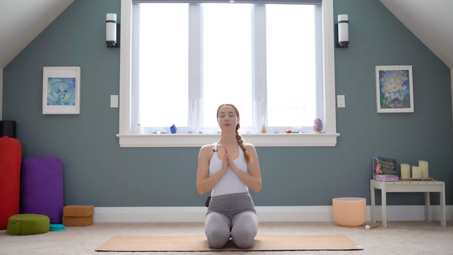 Yoga teacher kneeling on a mat after class