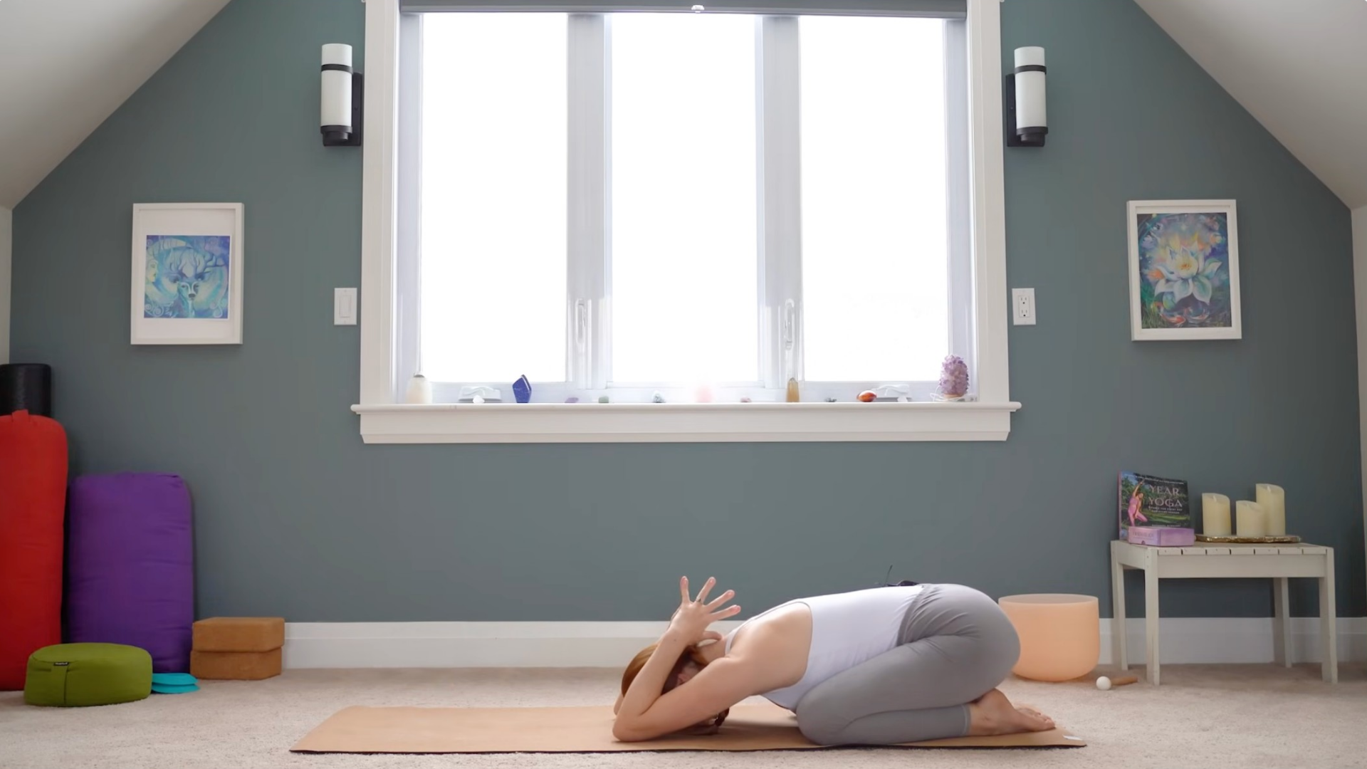 Woman kneeling on a mat with her hands in prayer behind her head