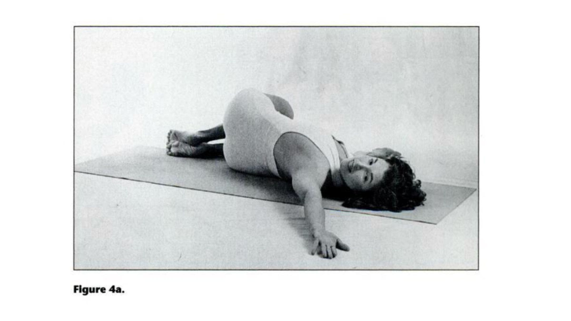 Woman practicing lying twist pose for tight shoulders.