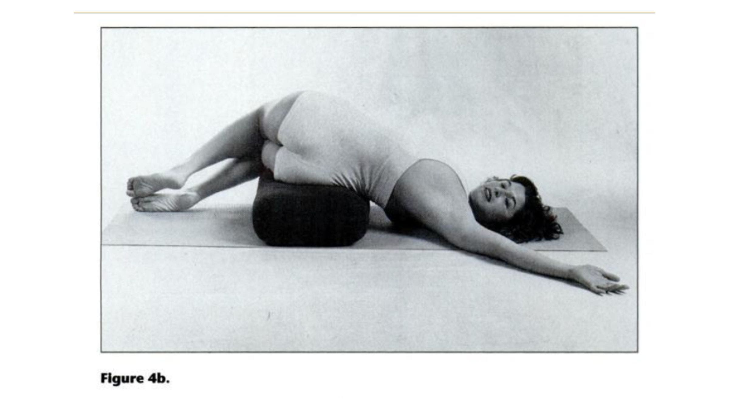 Woman practicing lying twist pose for tight shoulders.