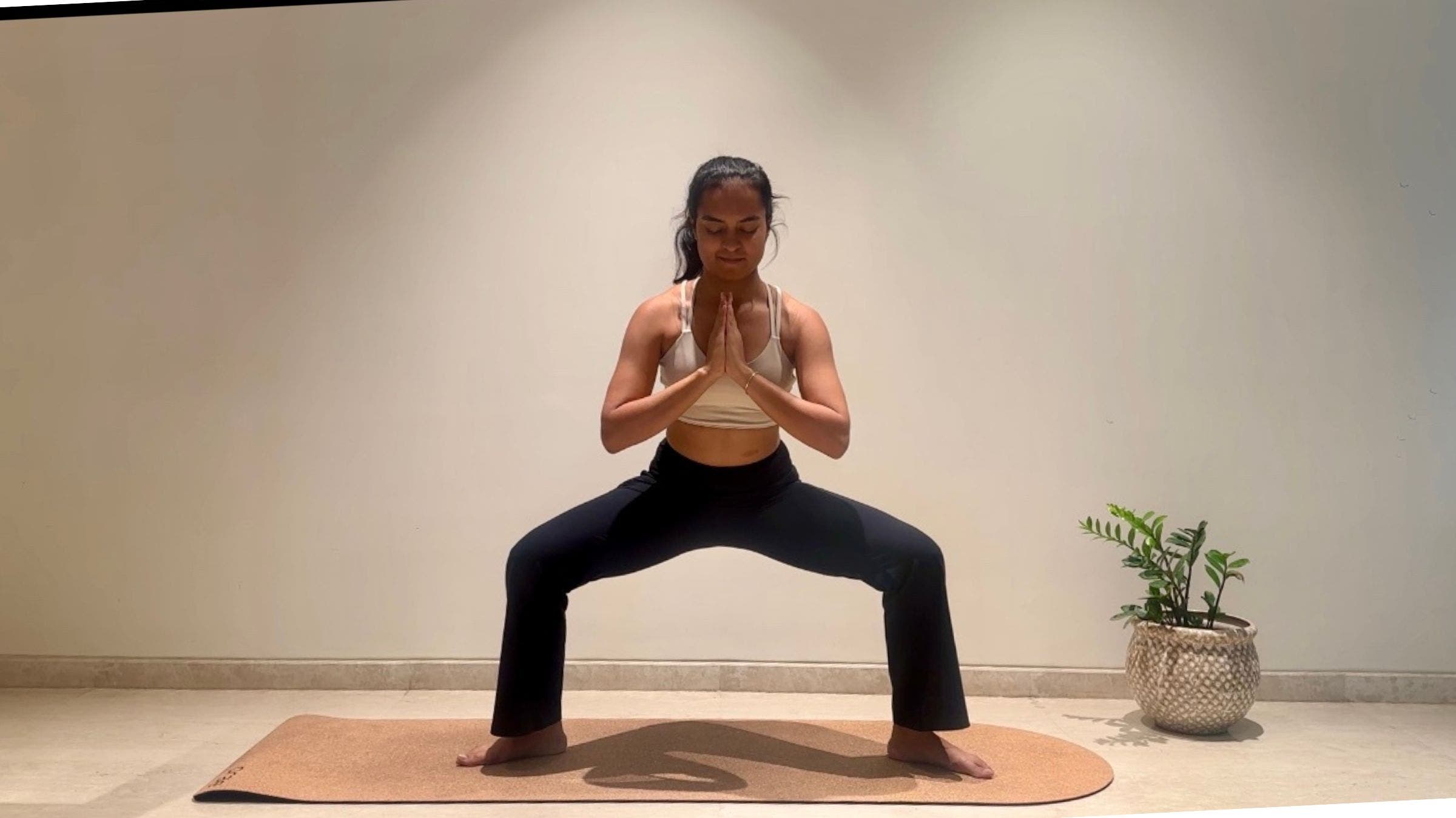 Yoga instructor doing goddess pose.