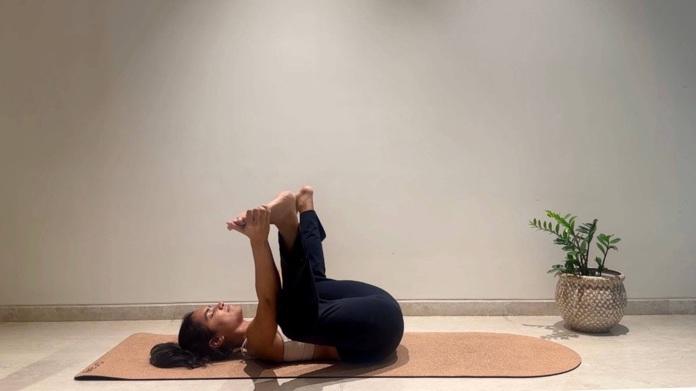 Yoga instructor doing Happy Baby.