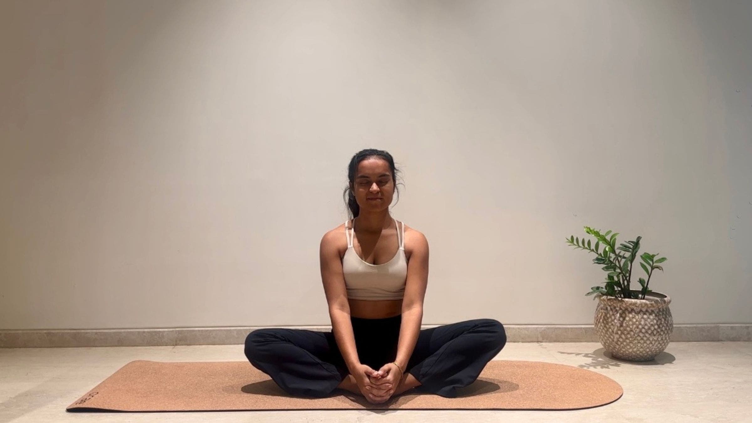 Yoga instructor doing Bound Angle pose.