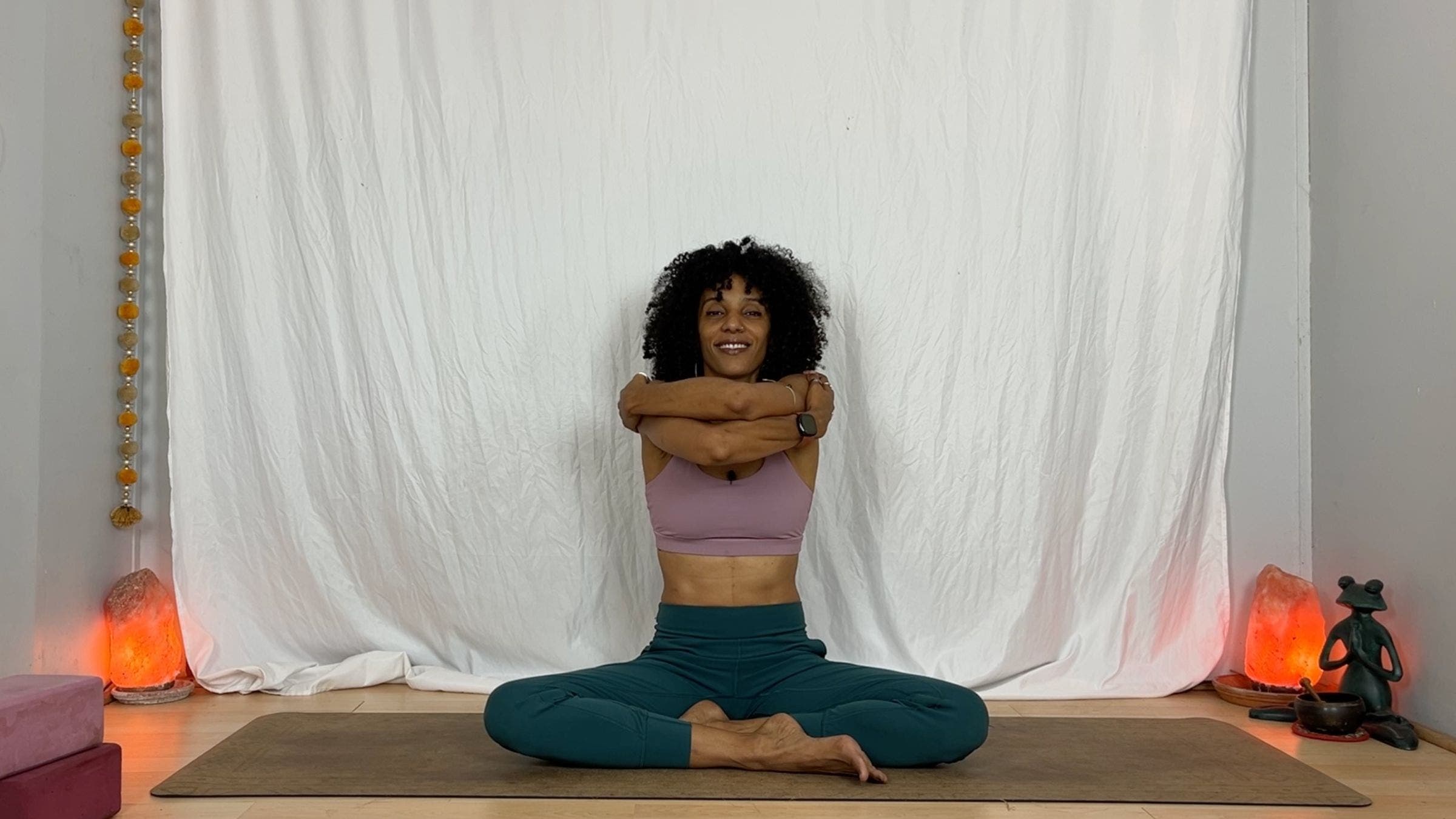 Yoga instructor practicing crossed arm extension exercise.