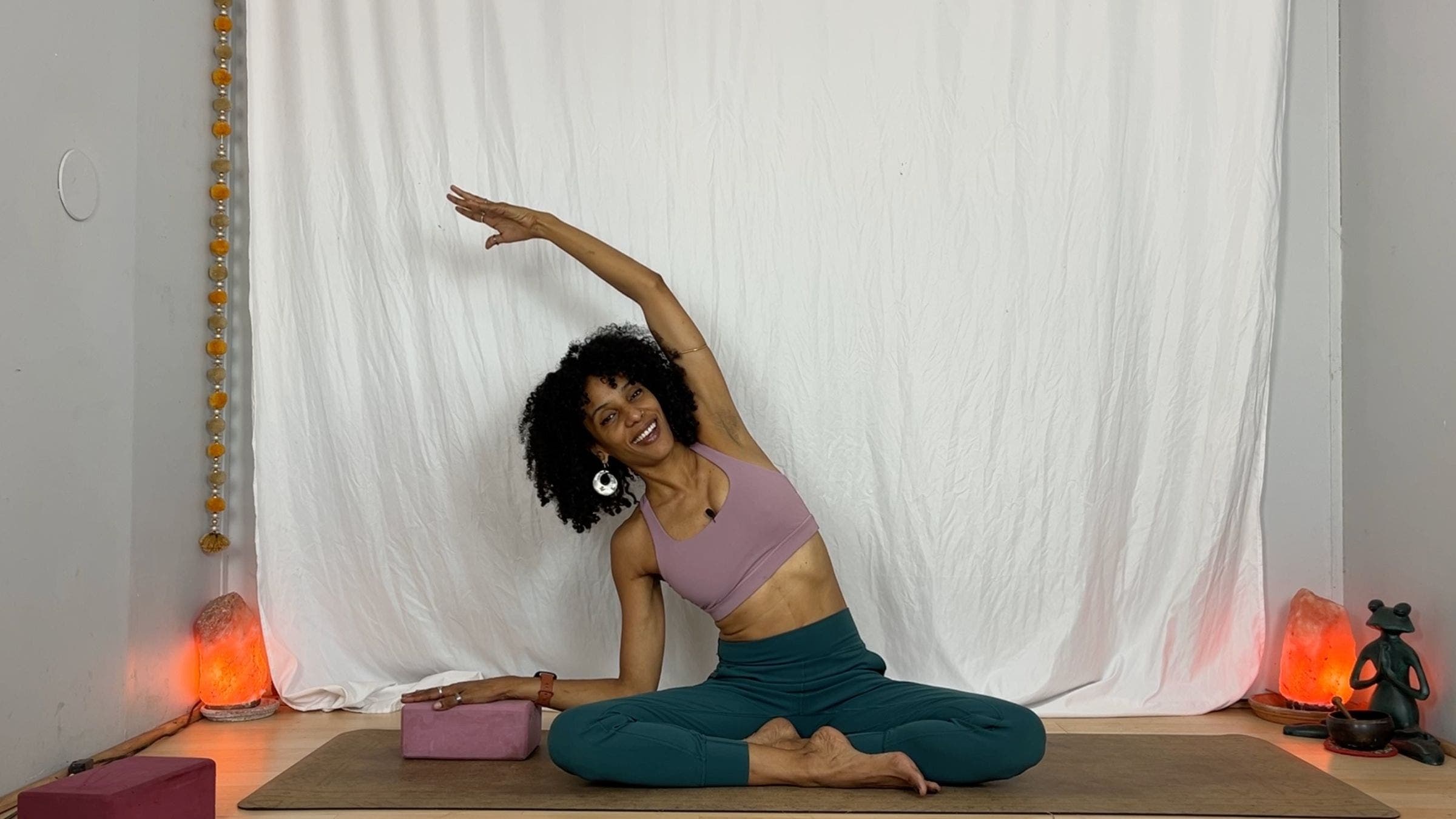 Yoga instructor practicing lateral stretch while sitting.