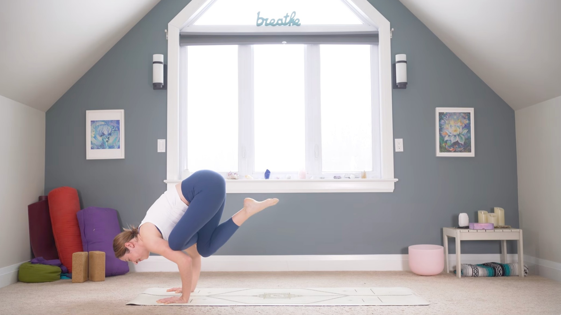 Woman leaning forward into the arm balance known as Flying Pigeon Pose