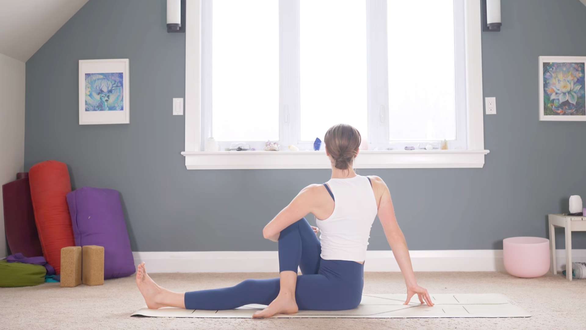 Woman sitting on a mat and twisting toward the right