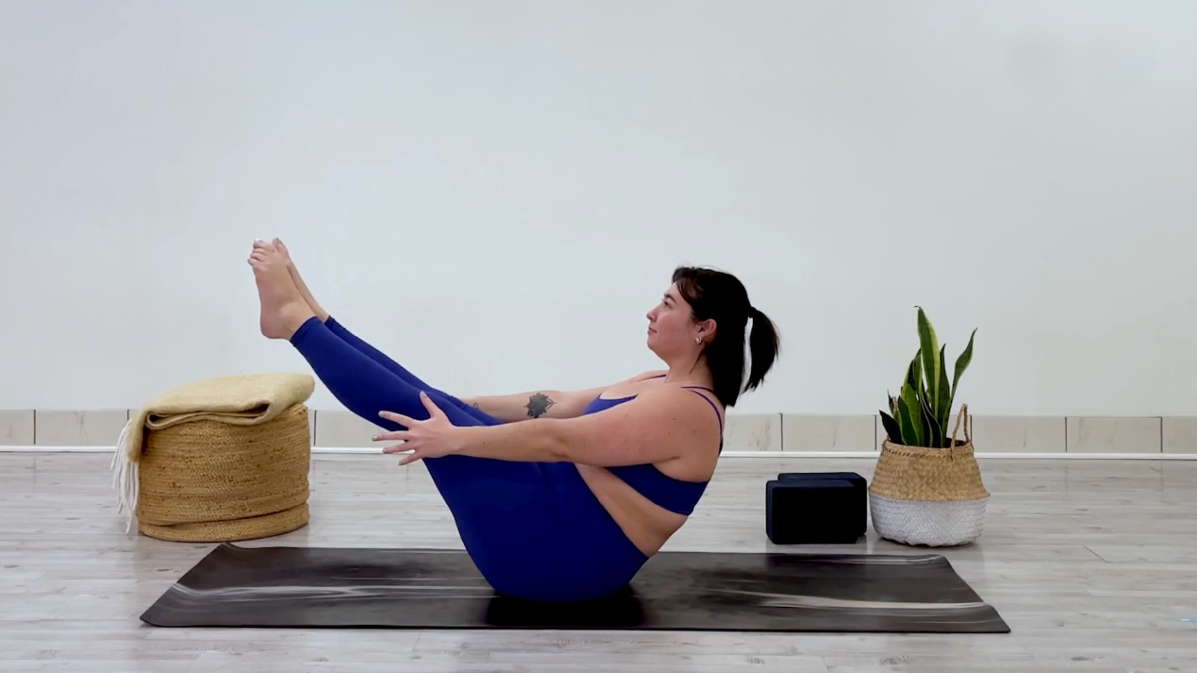 Yoga teacher Taylor Lorenz poses in boat pose, which is part of her yoga practice when she feels overstimulated