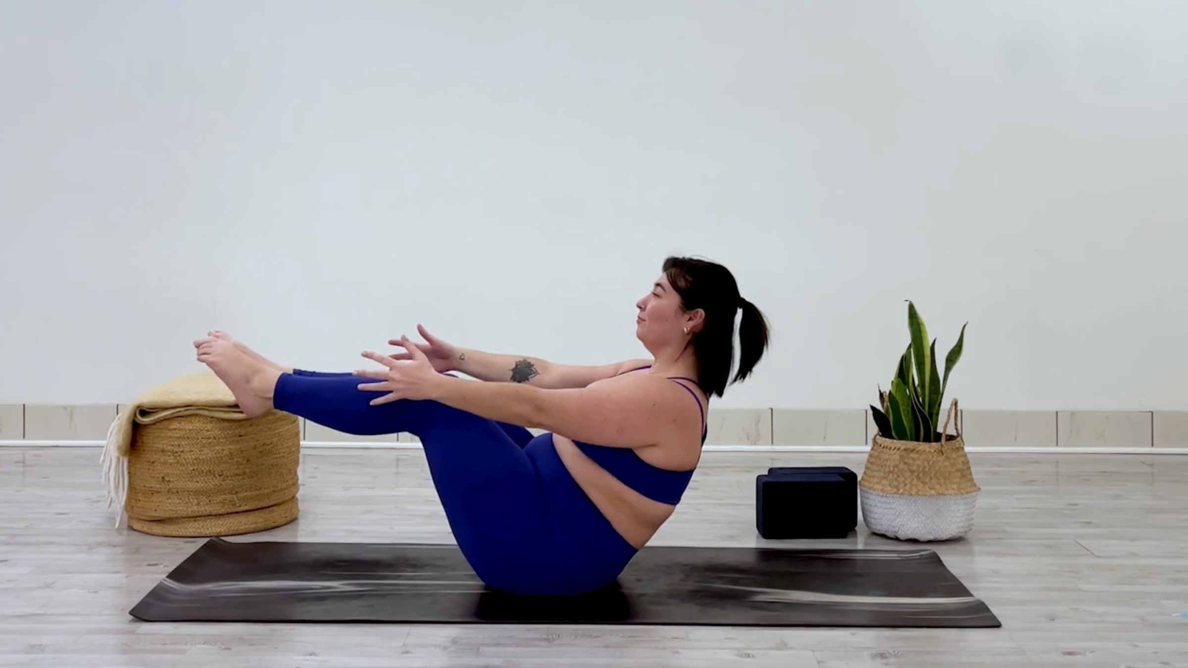 Yoga teacher Taylor Lorenz poses in boat pose, which is part of her yoga practice when she feels overstimulated