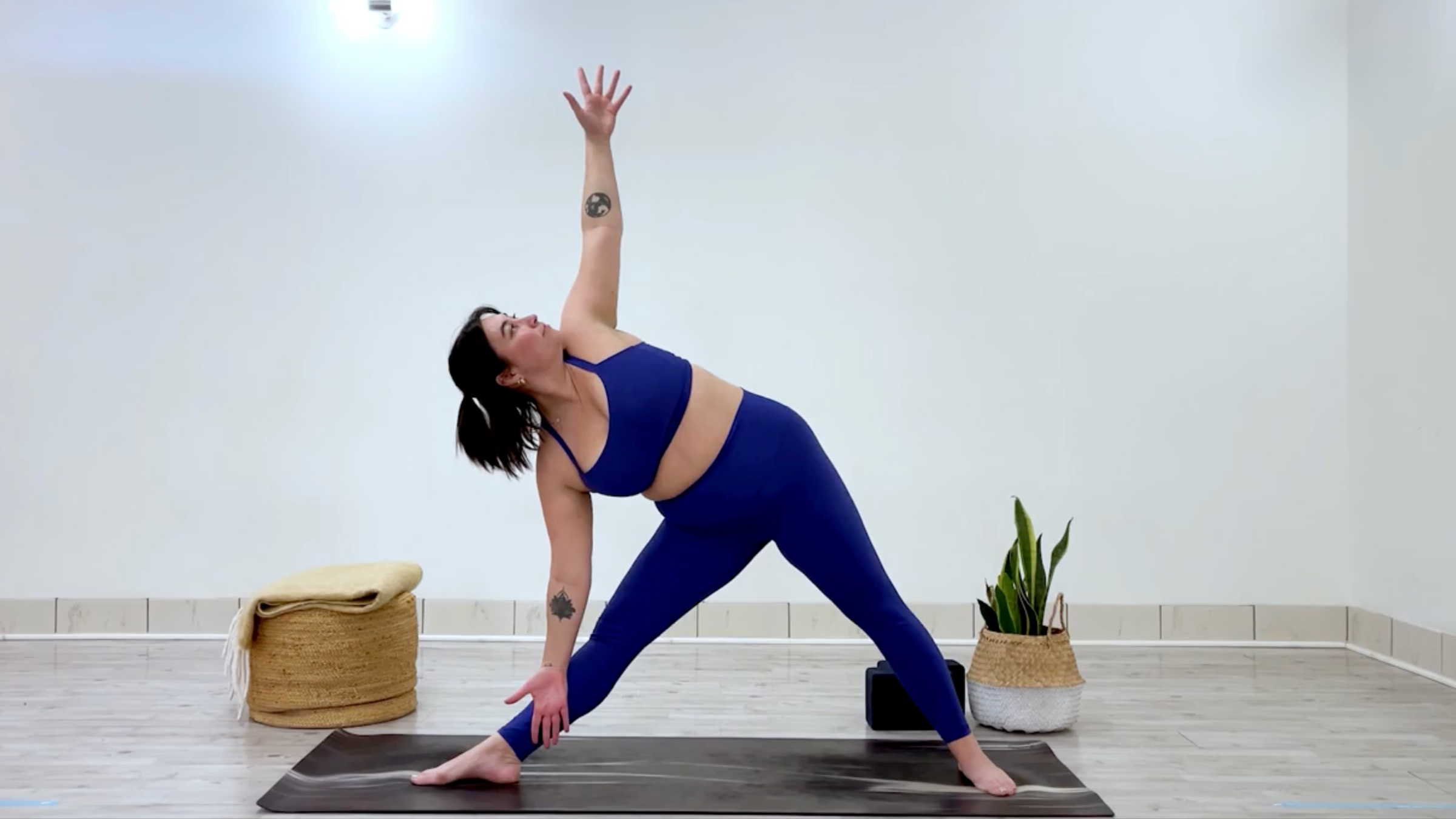 Yoga teacher Taylor Lorenz poses in triangle pose, which is part of her yoga practice for when you're feeling overstimulated