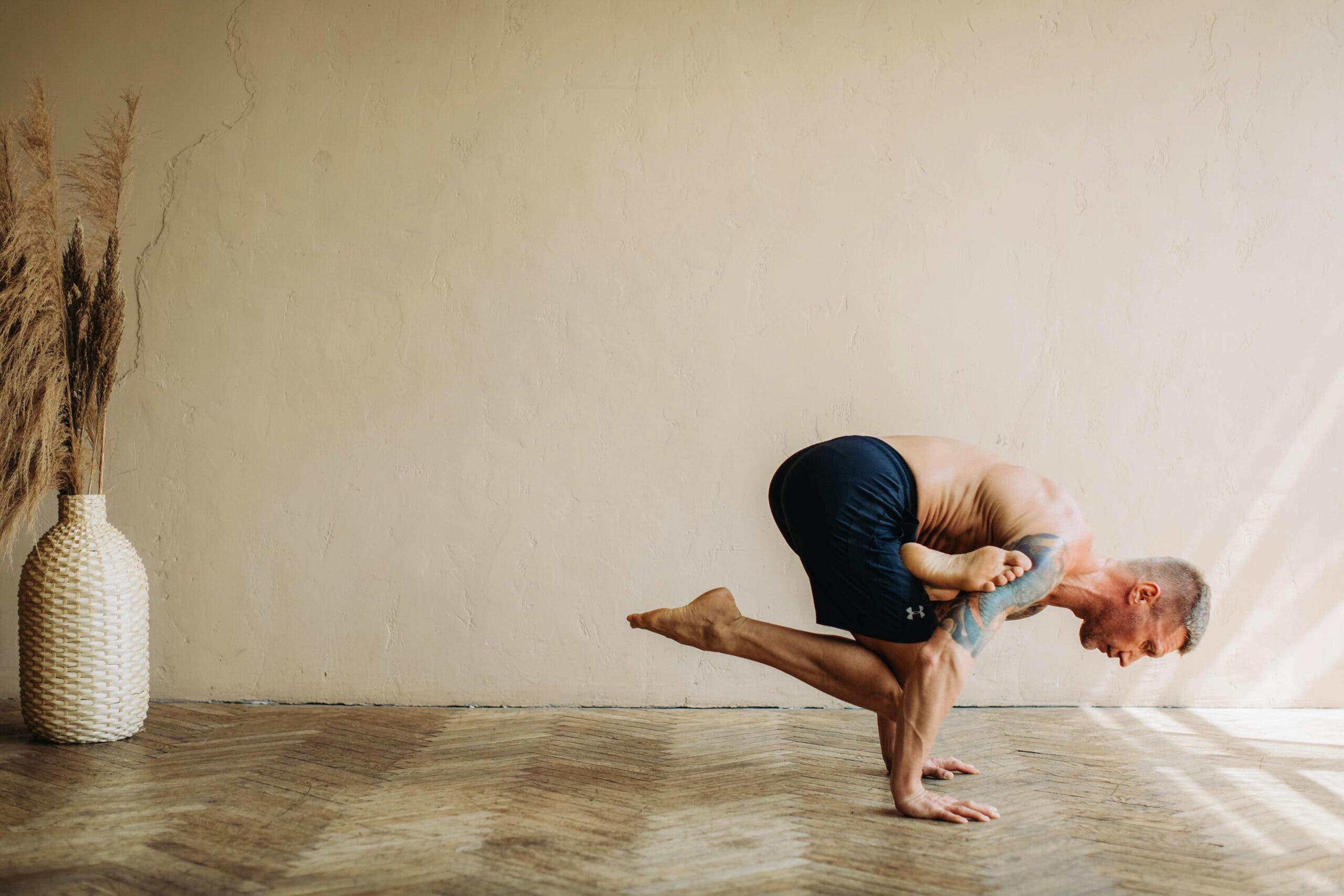 Man practicing Pigeon pose prep in Ashtanga yoga.