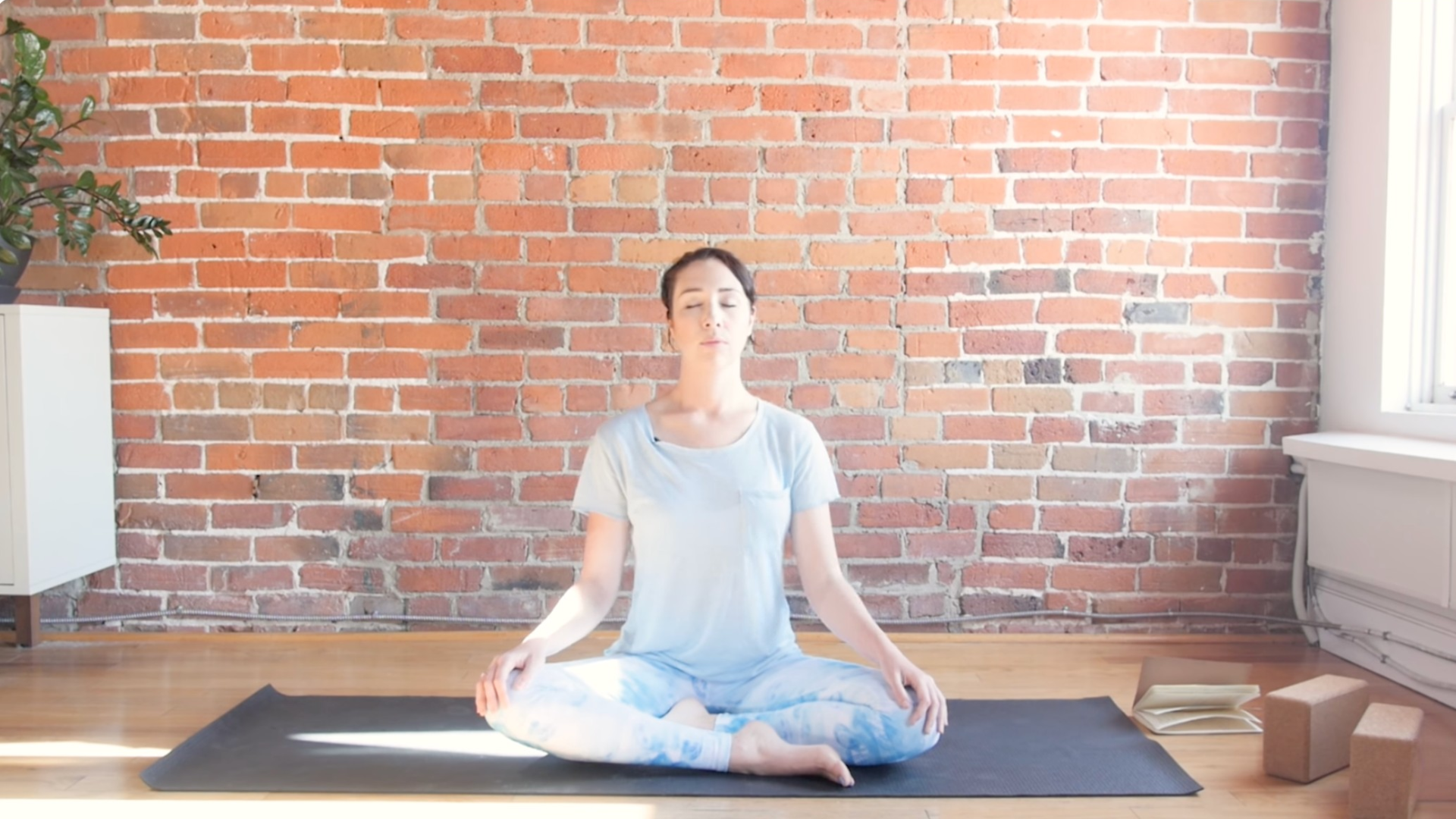 Woman sitting cross-legged and practicing Ujjayi breath during yin yoga for throat chakra