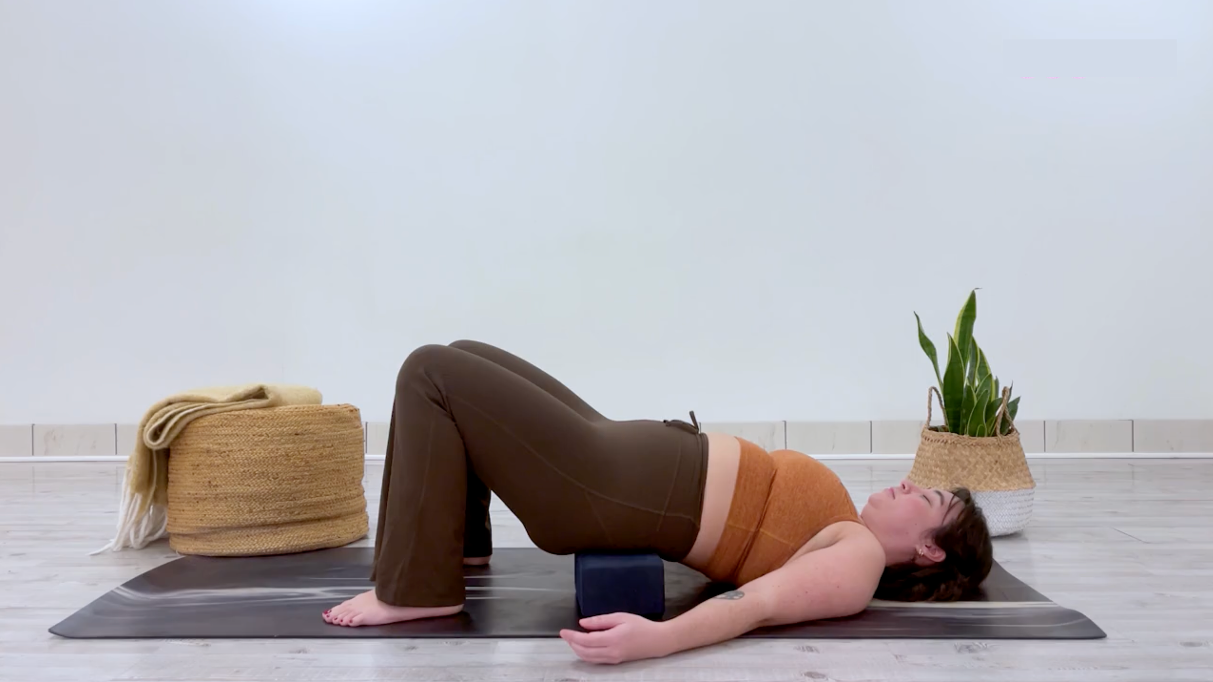 Yoga teacher Taylor Lorenz in Supported Bridge Pose, part of her yin yoga for energy practice