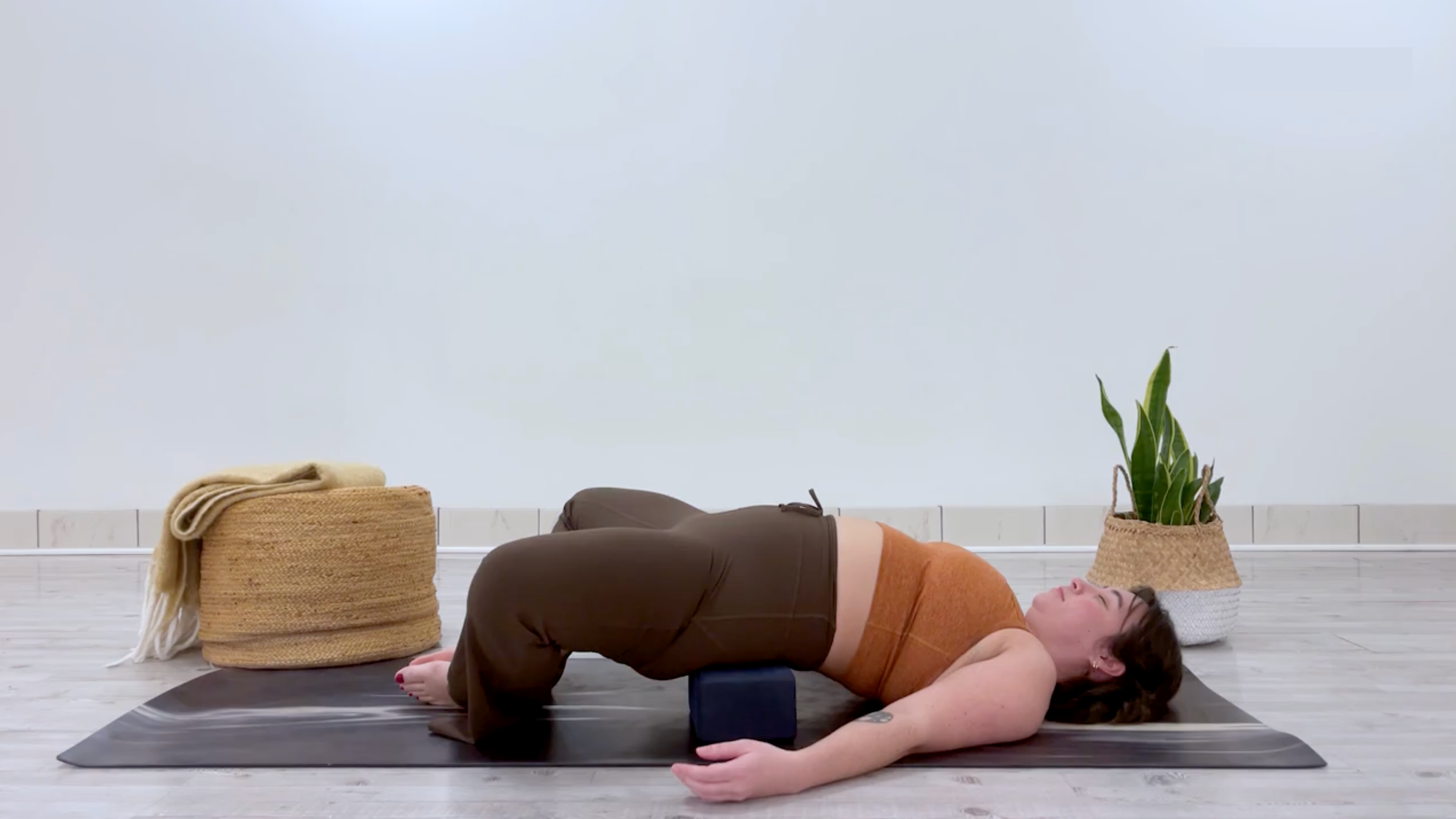 Yoga teacher Taylor Lorenz in Supported Reclined Butterfly Pose, part of her yin yoga for energy practice