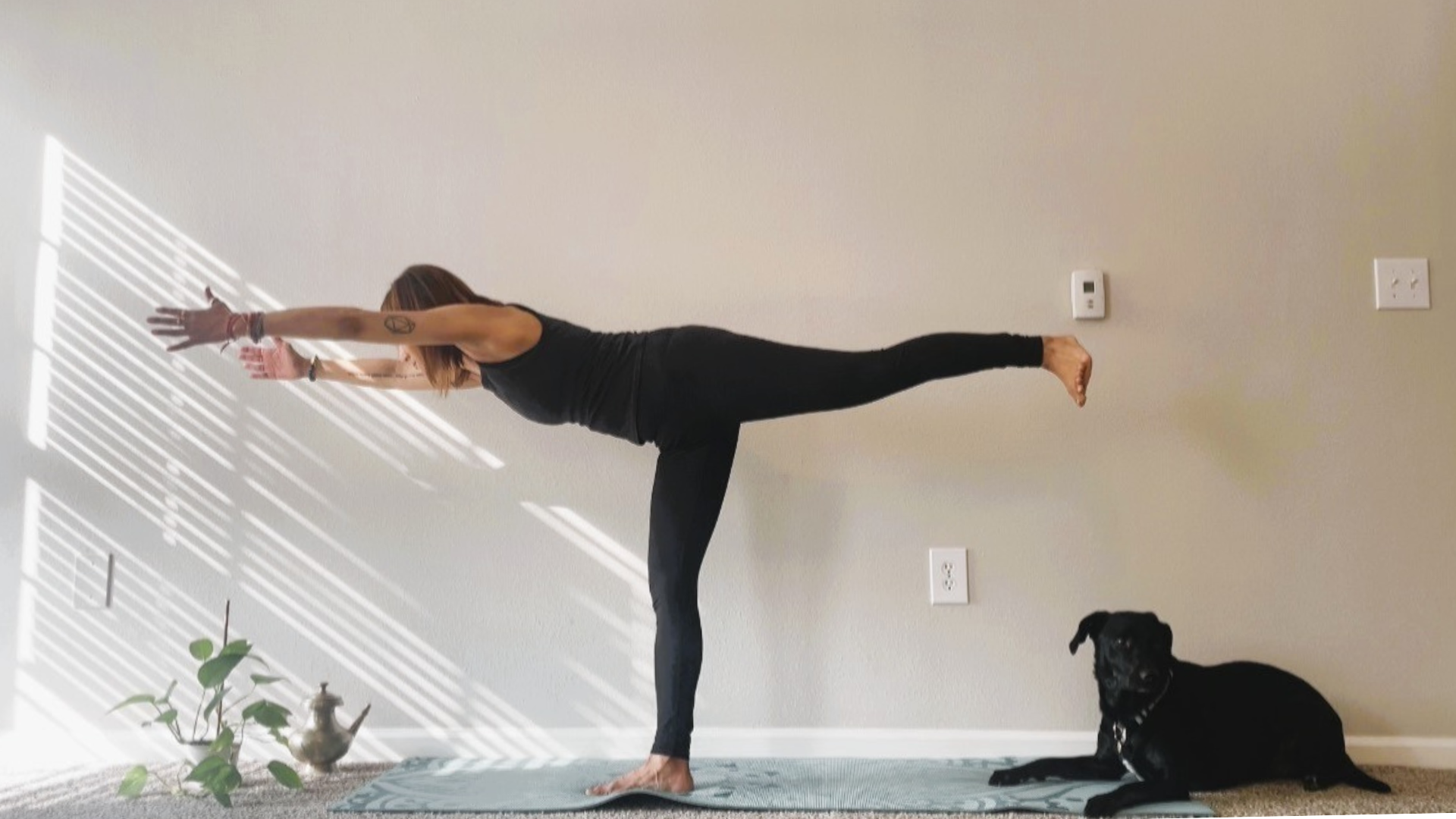 Woman practicing balancing on one leg in Warrior 3 Pose during a yoga for freeze response practice