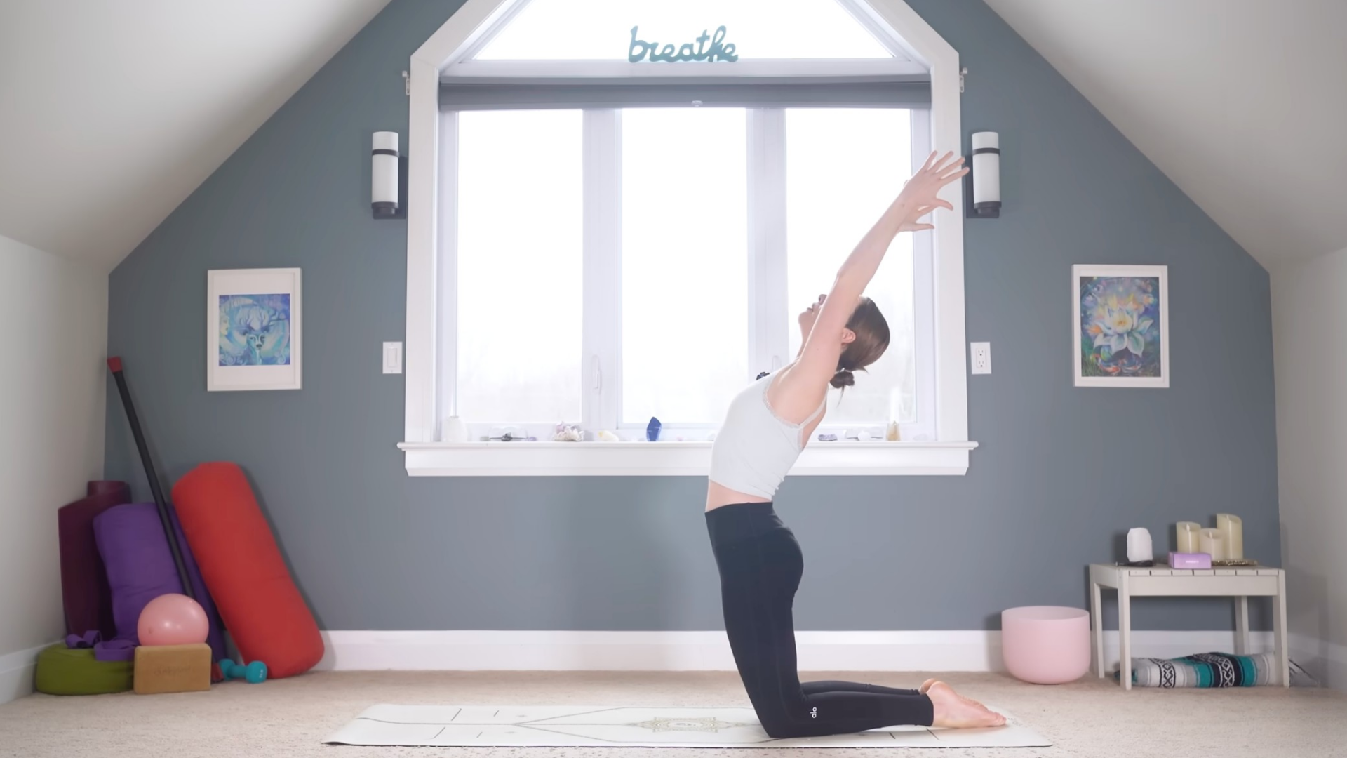 Woman kneeling on a yoga mat with her arms overhead during a 10-minute morning yoga practice
