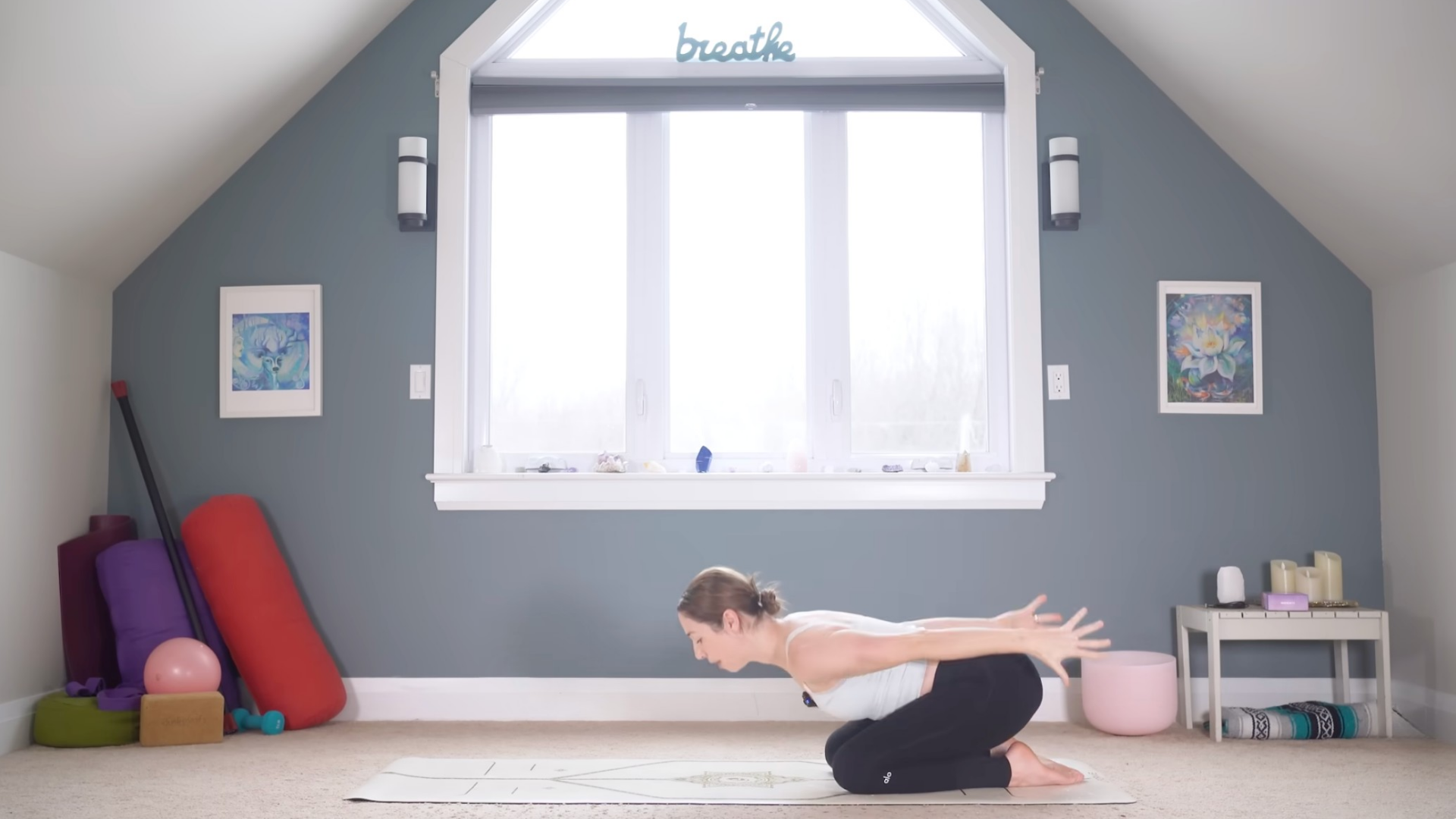 Woman leaning forward while kneeling on a yoga mat