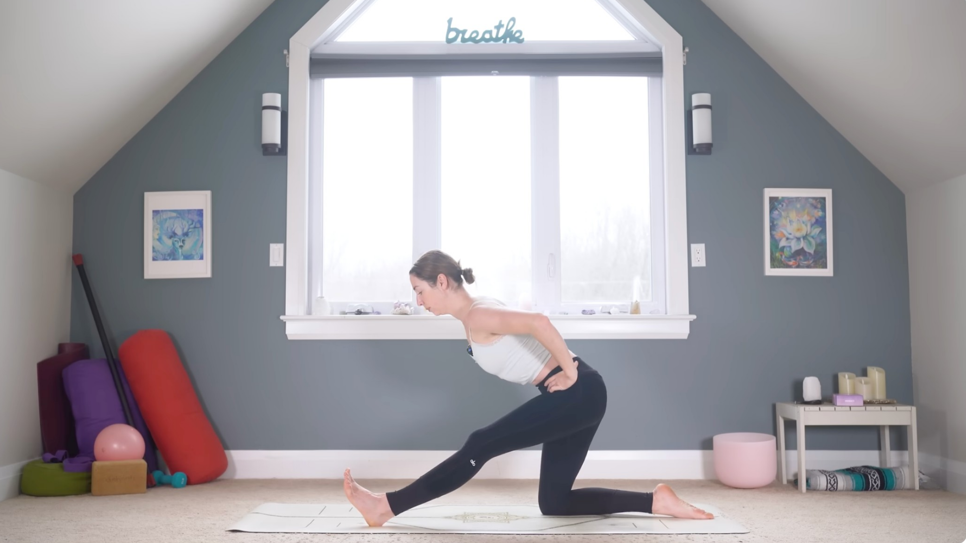 Woman leaning forward in Half Splits while kneeling on a yoga mat