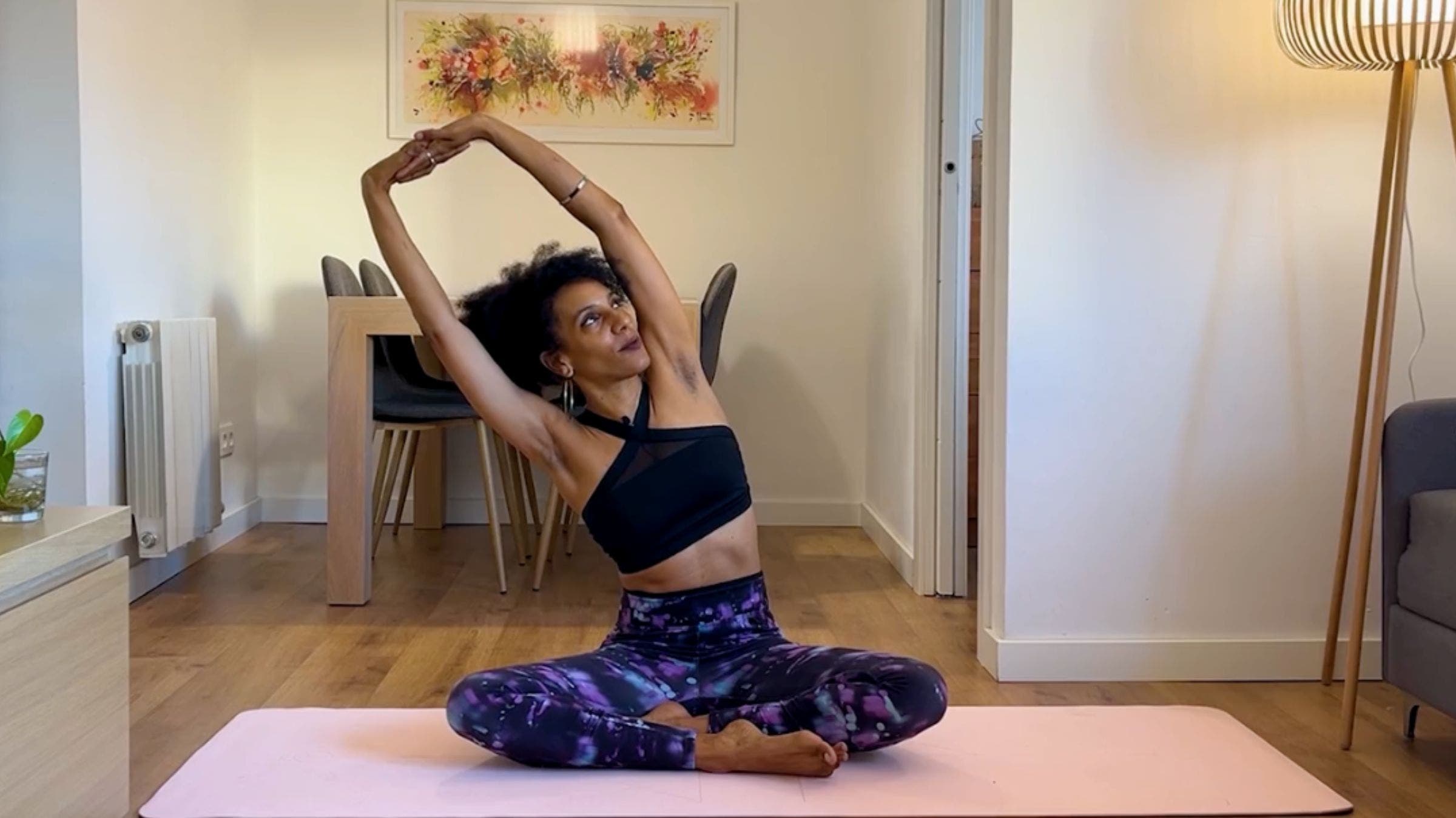 Yoga instructor practicing lateral stretch while sitting.