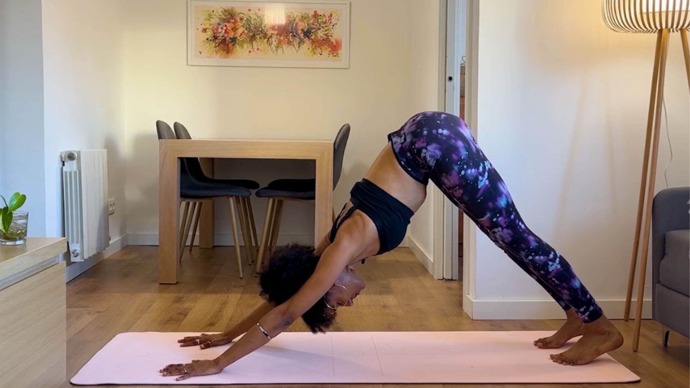 Yoga teacher practicing Downward Dog.