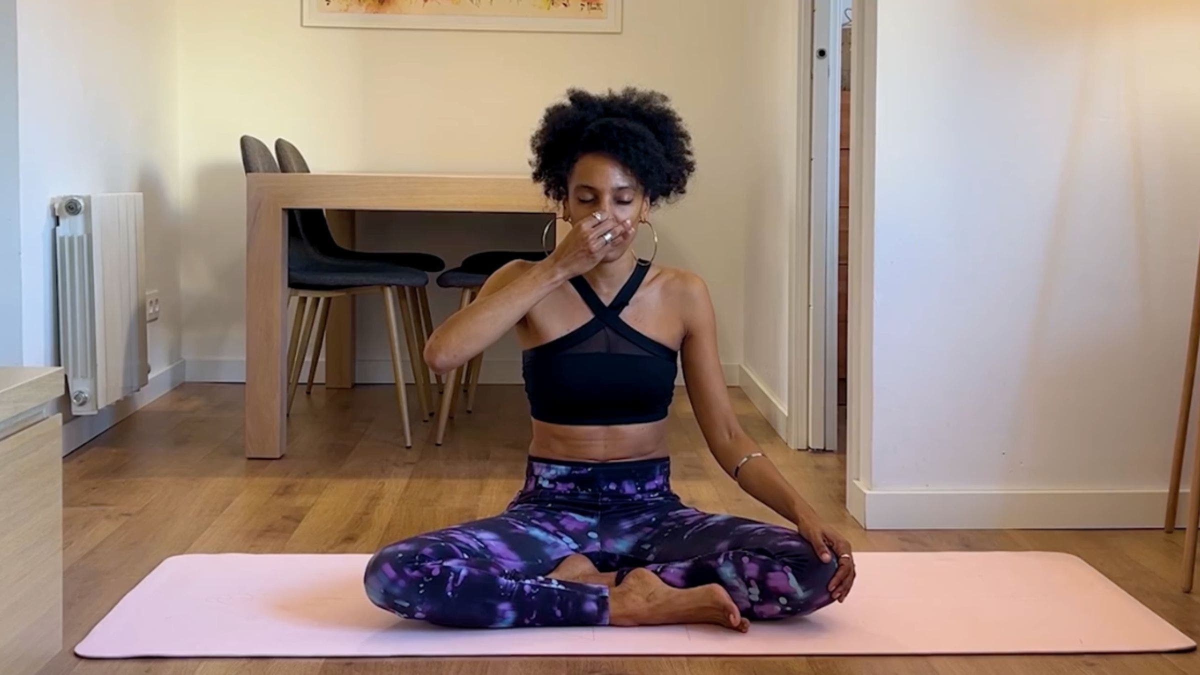 Yoga teacher practicing alternate nostril breathing.