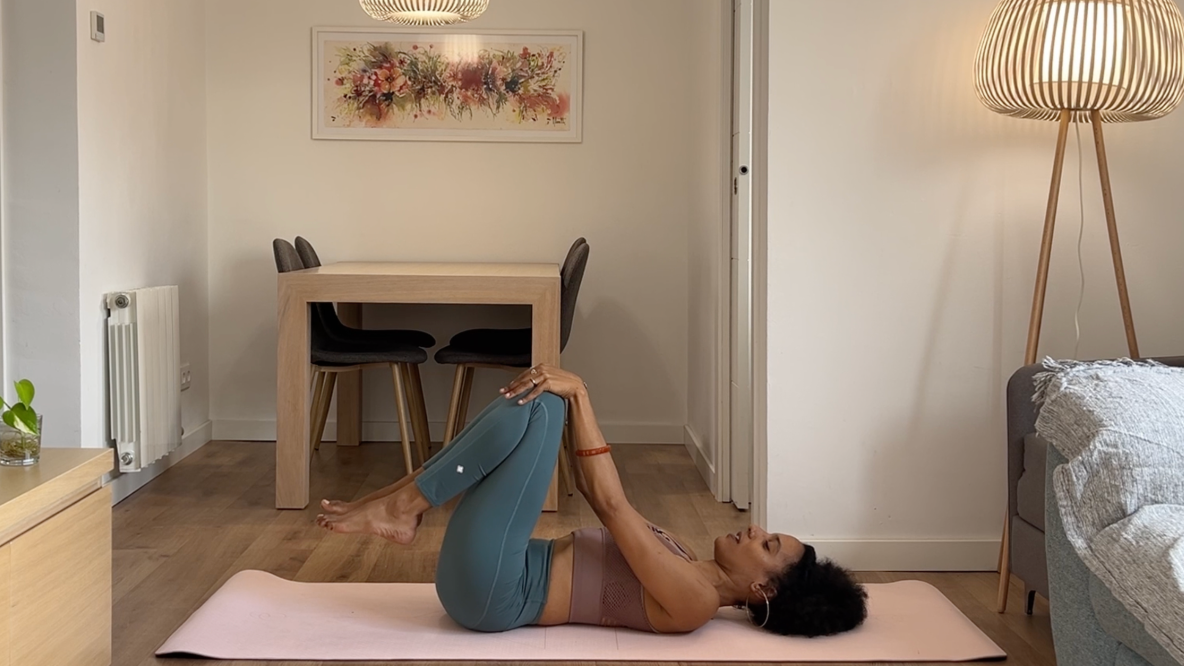 Yoga teacher practicing Knees to Chest.