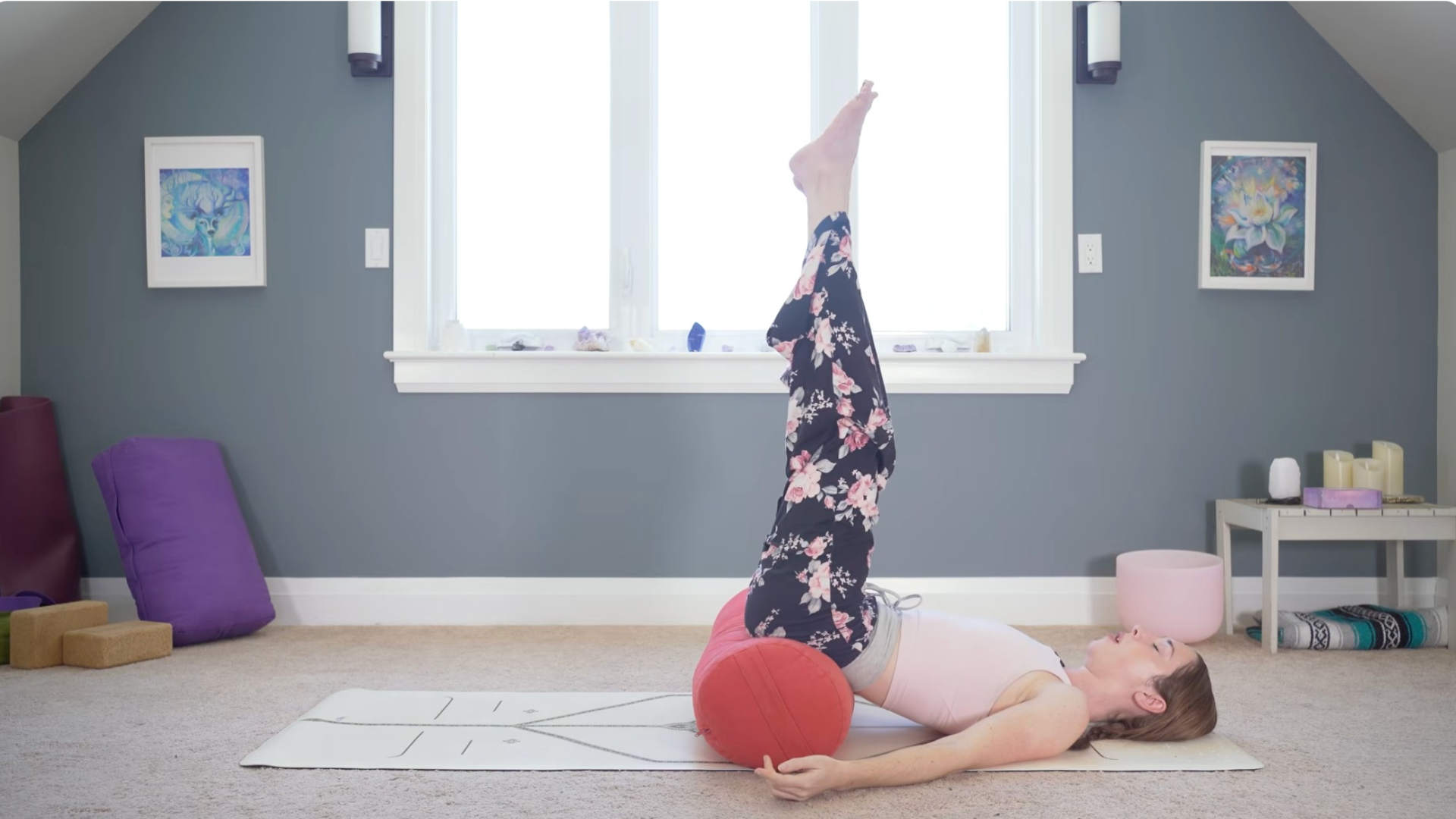 Woman lying on her back with her legs reaching straight toward the ceiling