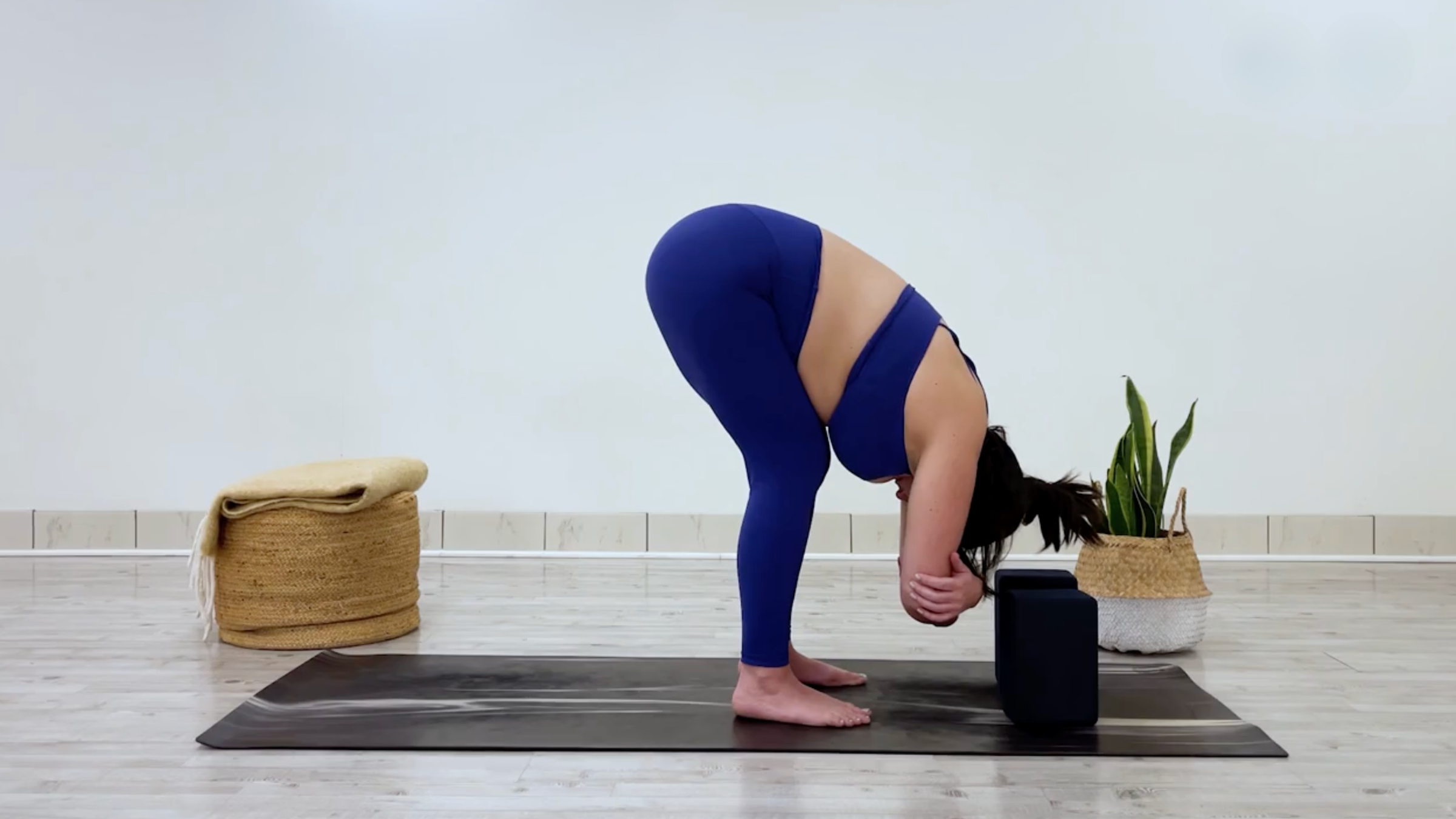 Yoga teacher Taylor Lorenz in Standing Forward Bend, part of her yin yoga for tension practice