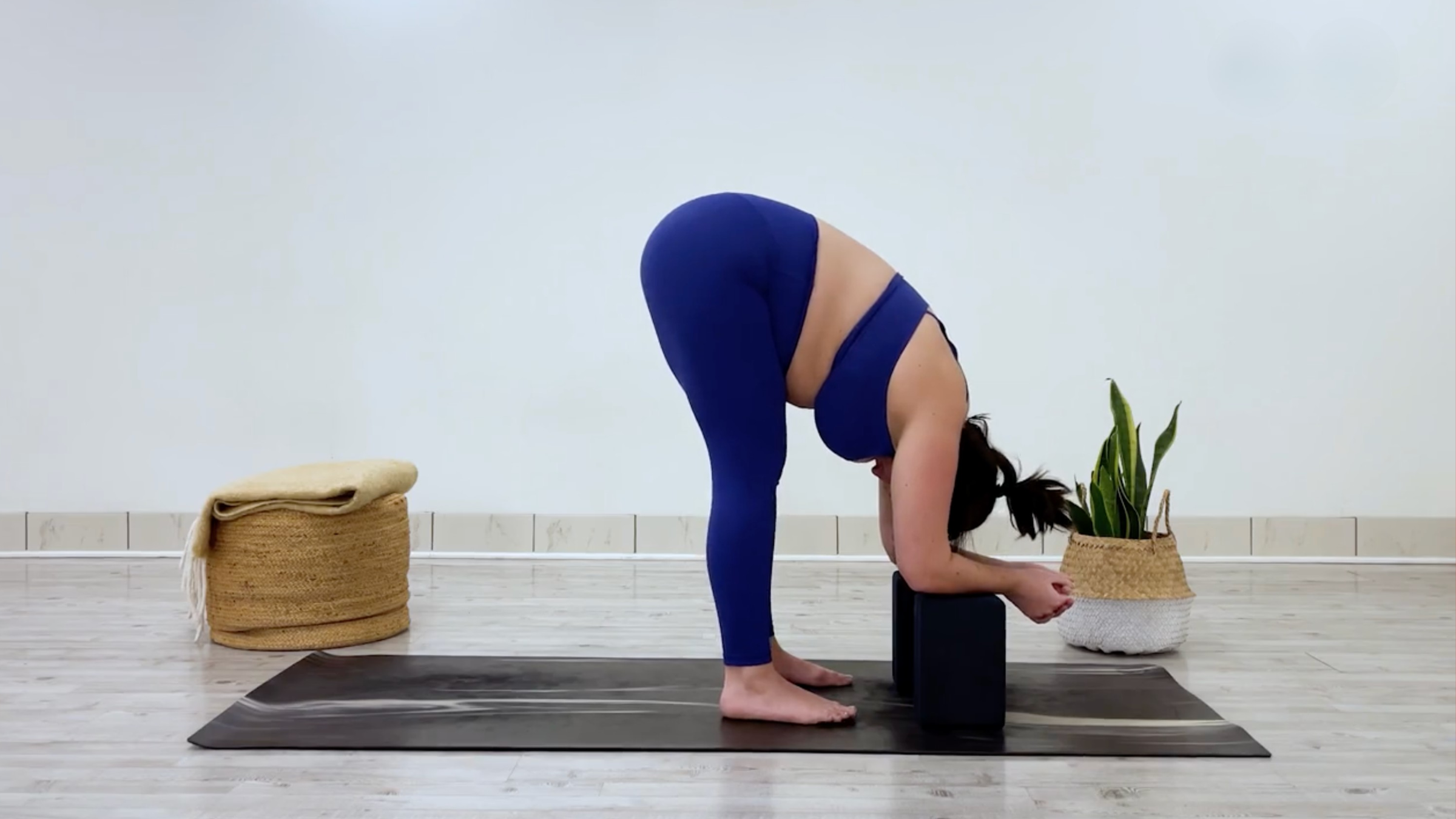 Yoga teacher Taylor Lorenz in Standing Forward Bend, part of her yin yoga for tension practice