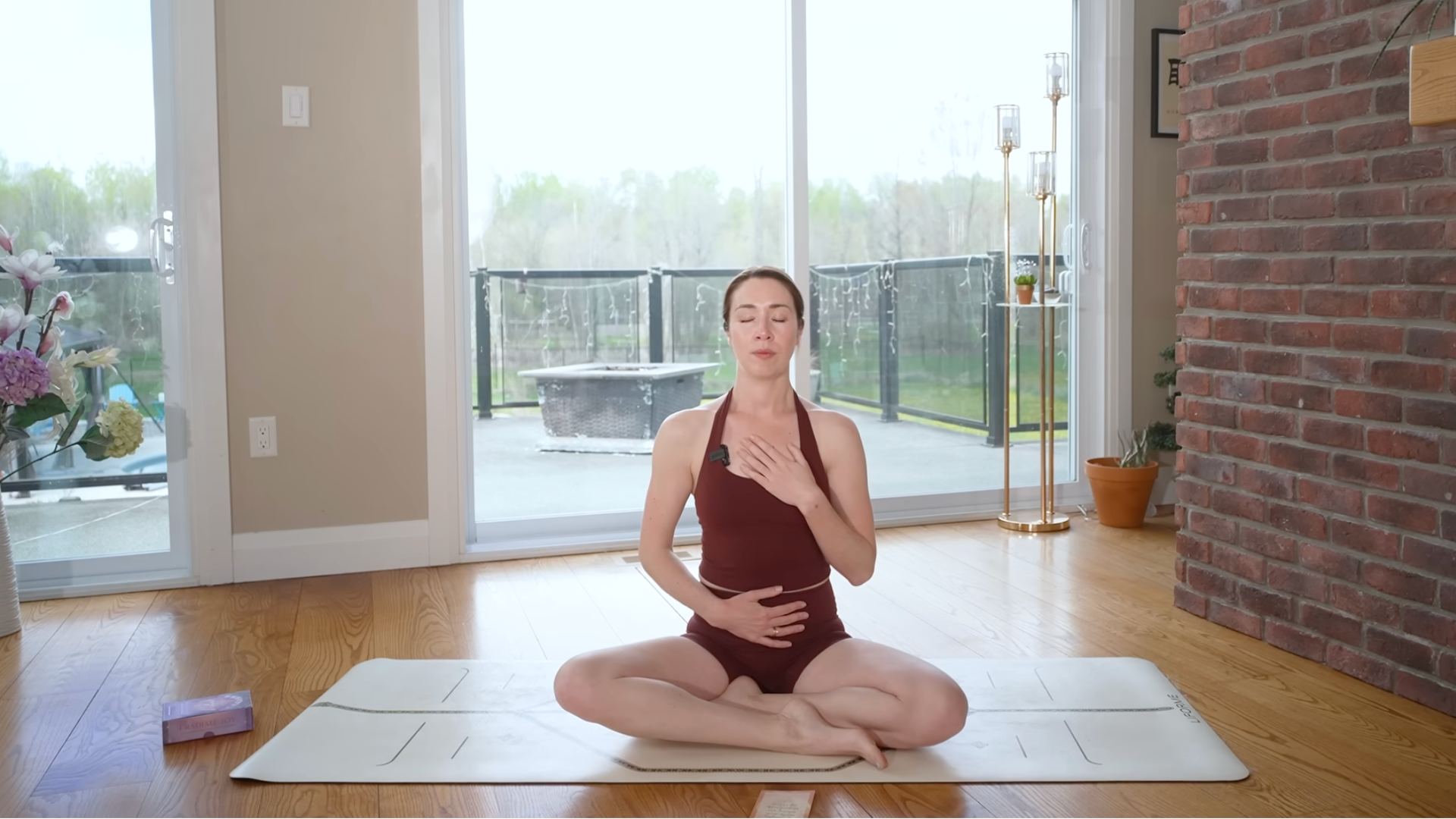 A woman sits cross-legged on a yoga mat and sets an intention