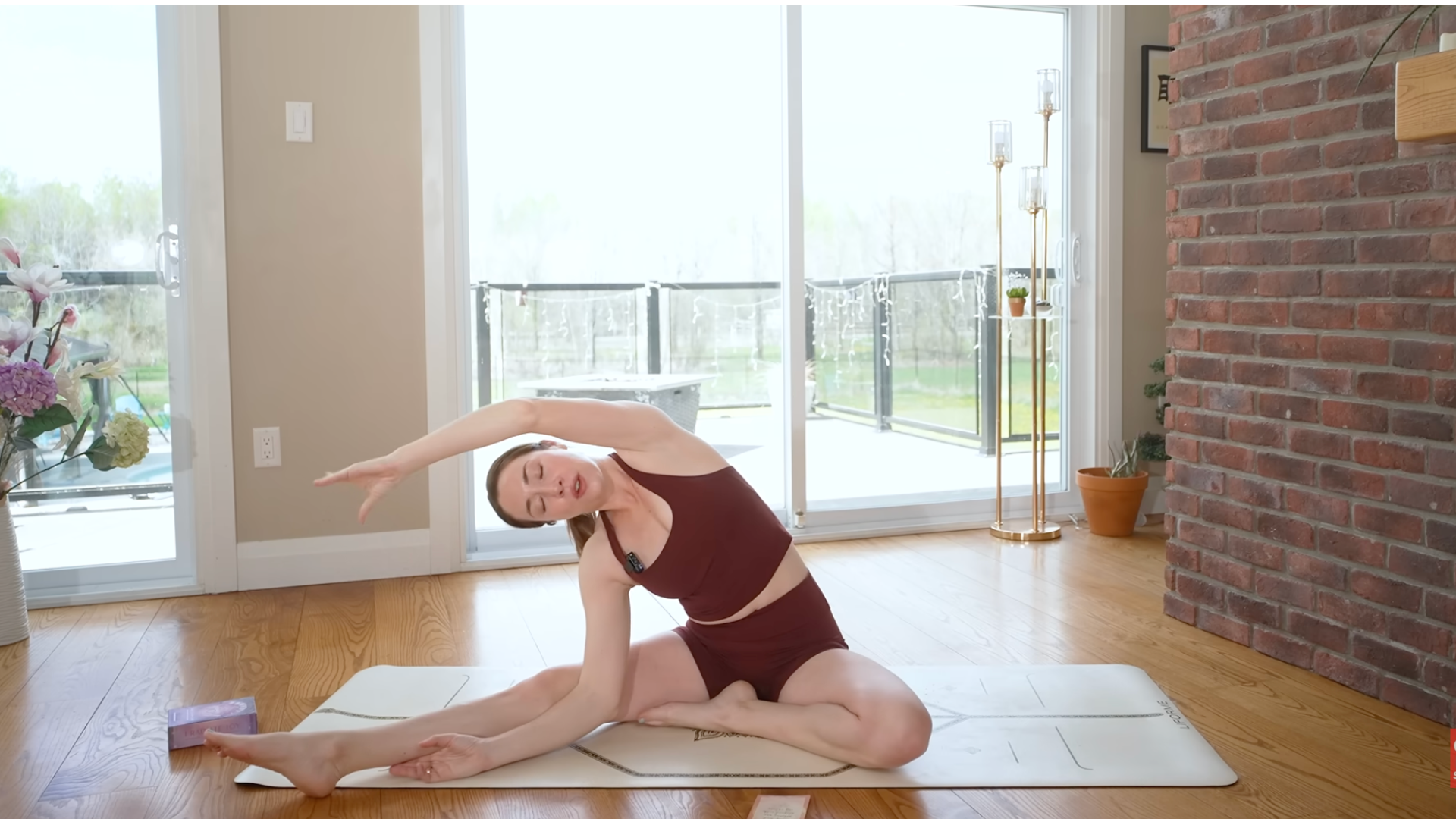 Woman sitting with one leg straight and the other leg bent in a seated side-body stretch