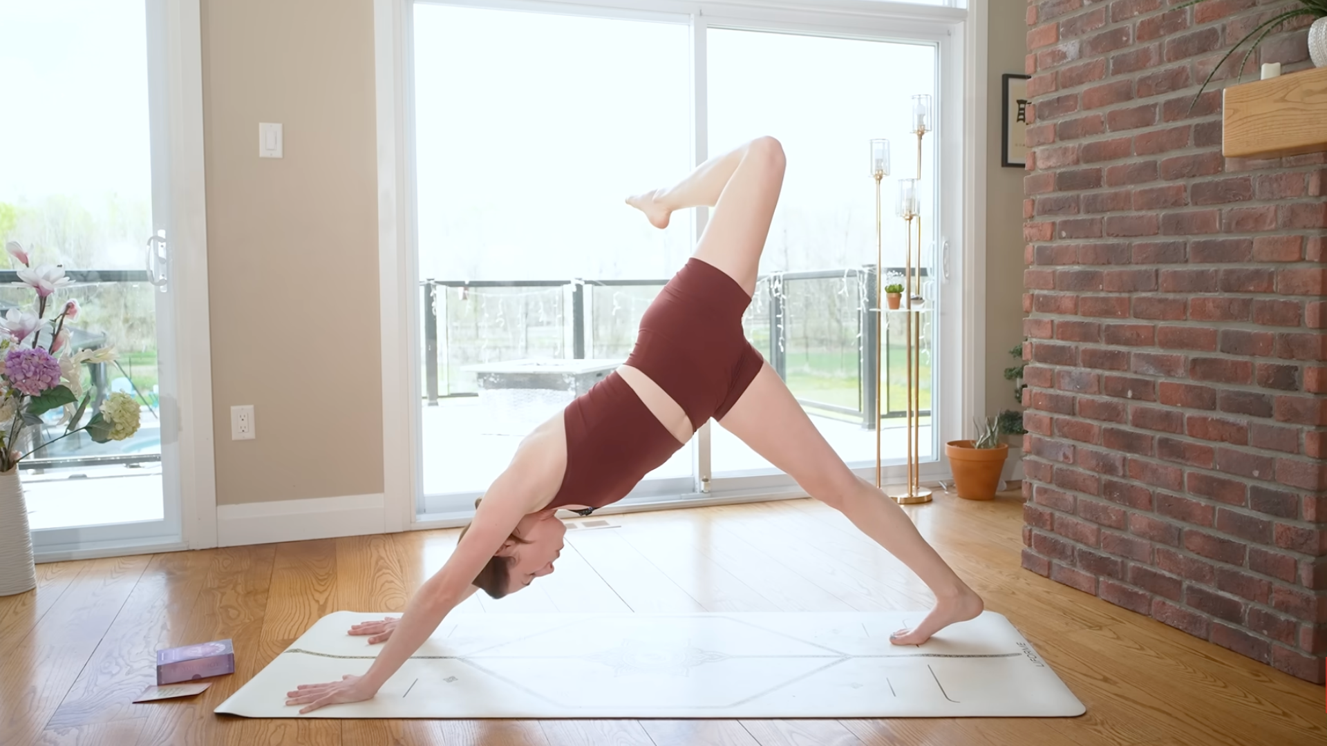 Woman in Three-Legged Dog on a yoga mat practicing a 10-minute morning yoga routine