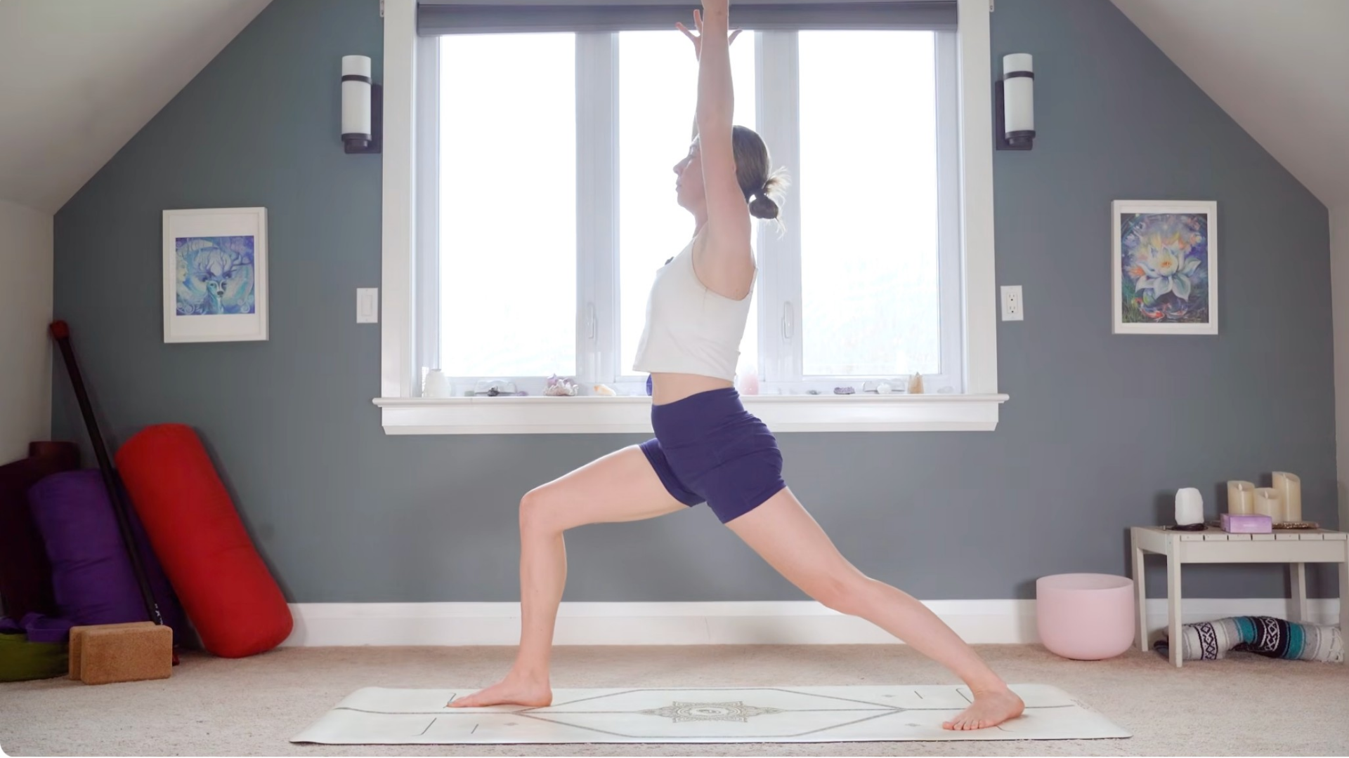 Woman practicing Warrior 1 Pose on a yoga mat