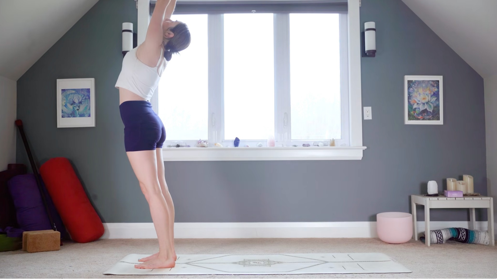 Woman practicing 15-minute morning yoga while reaching her arms upward toward the ceiling