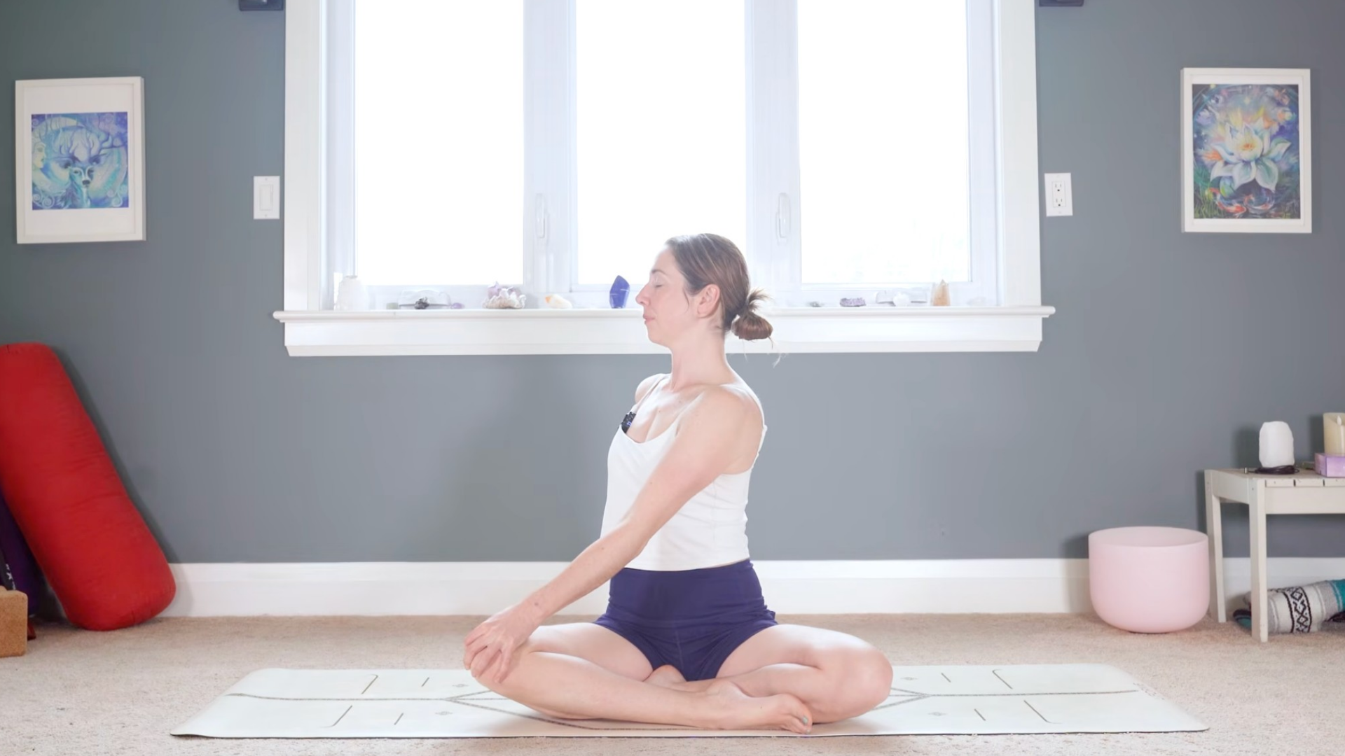 Woman sitting cross-legged and twisting toward her right