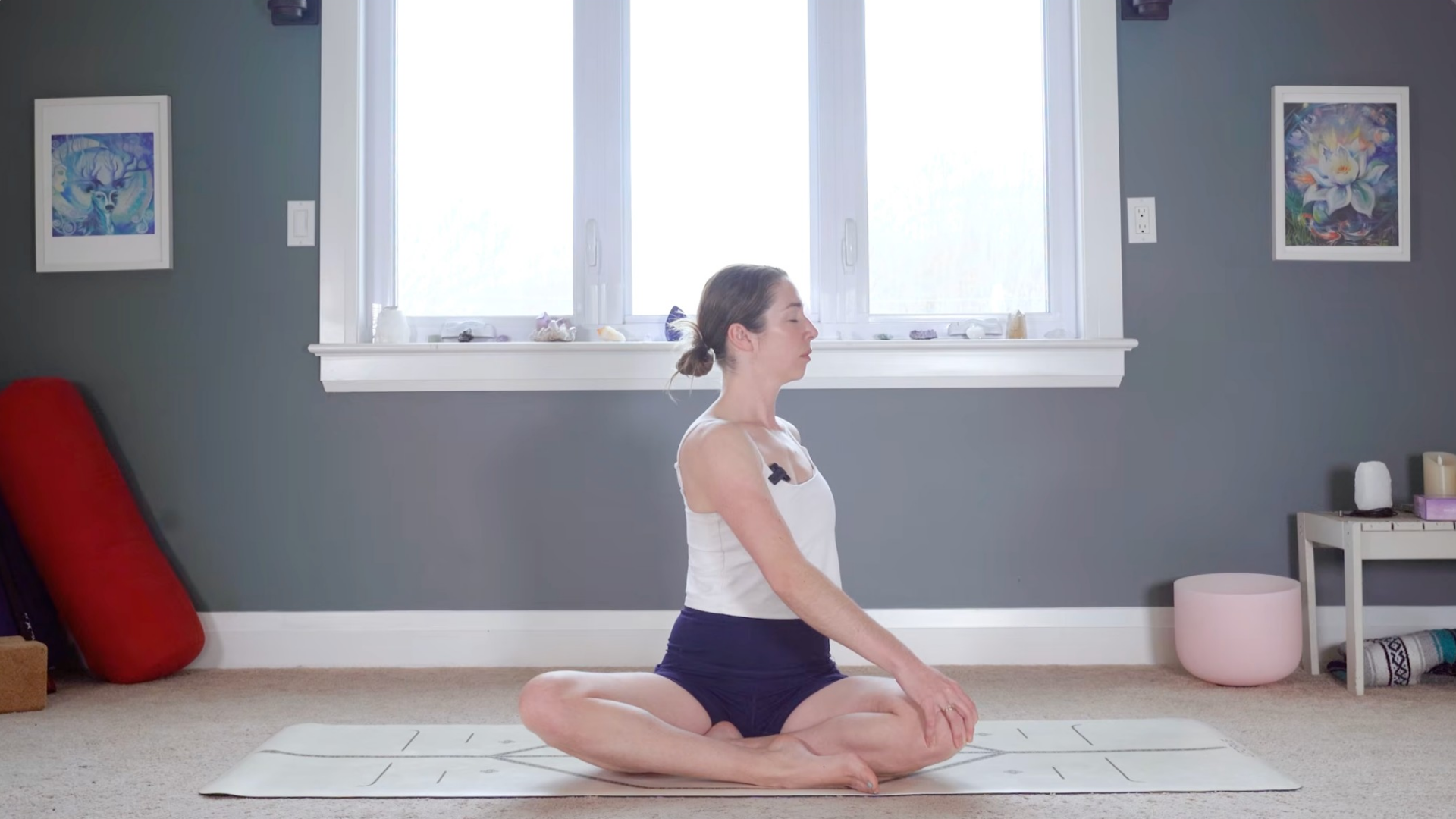 Woman twisting toward her left as she's sitting cross-legged
