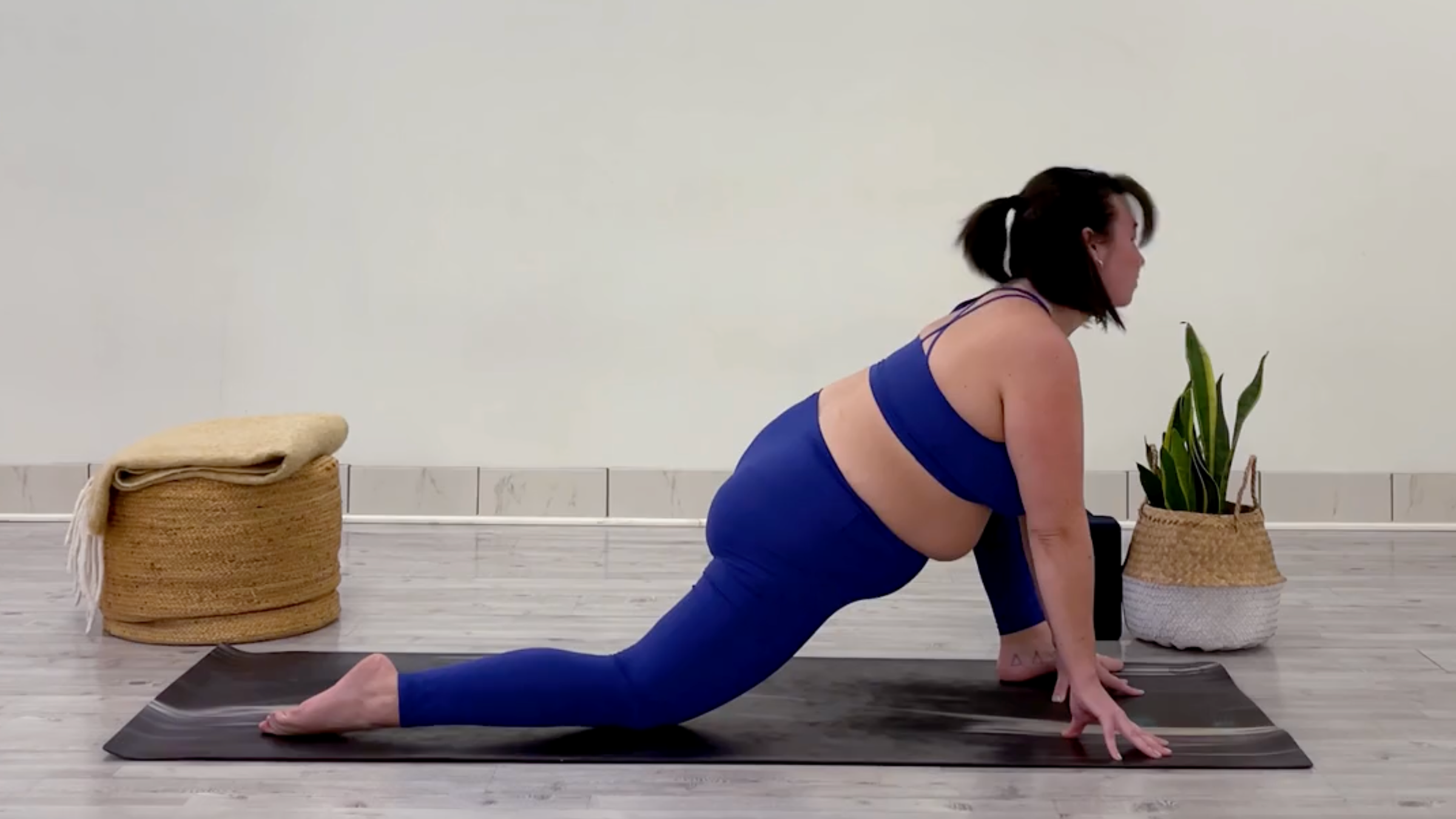 Yoga teacher Taylor Lorenz in Lizard Pose, part of her 15 minute yoga flow for a full body stretch