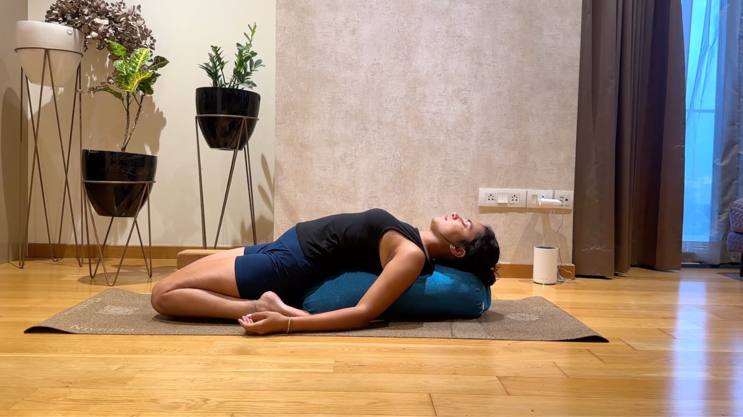 Person practicing Supported Reclining Hero Pose.