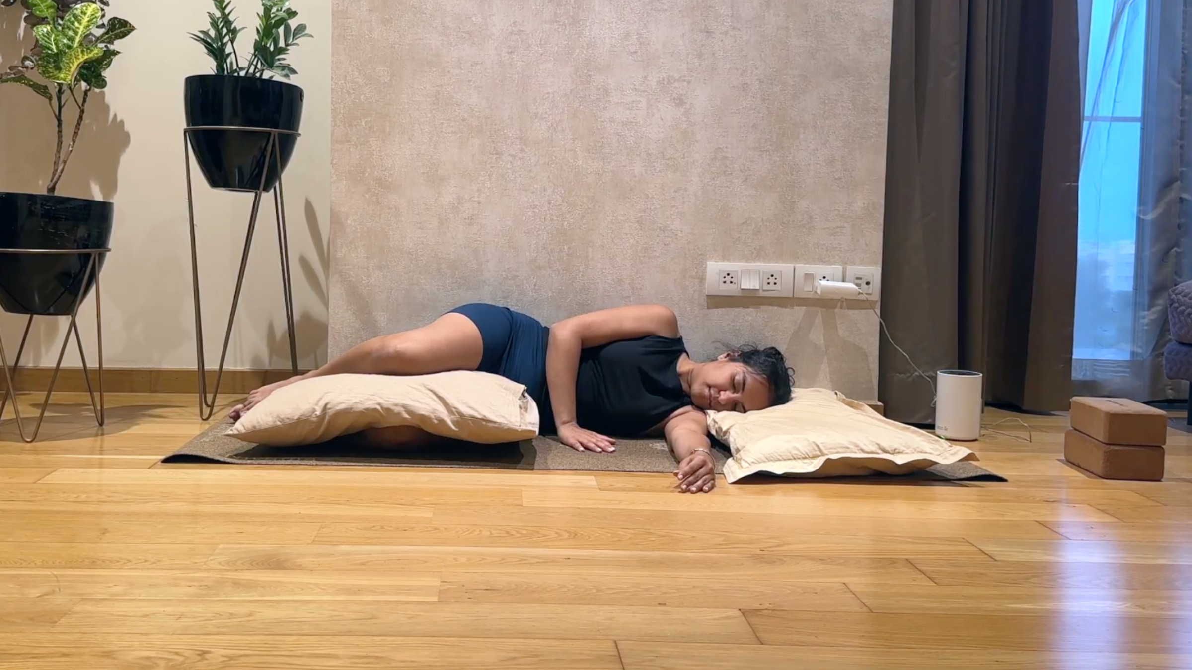Yoga teacher practicing Side-Lying Savasana.