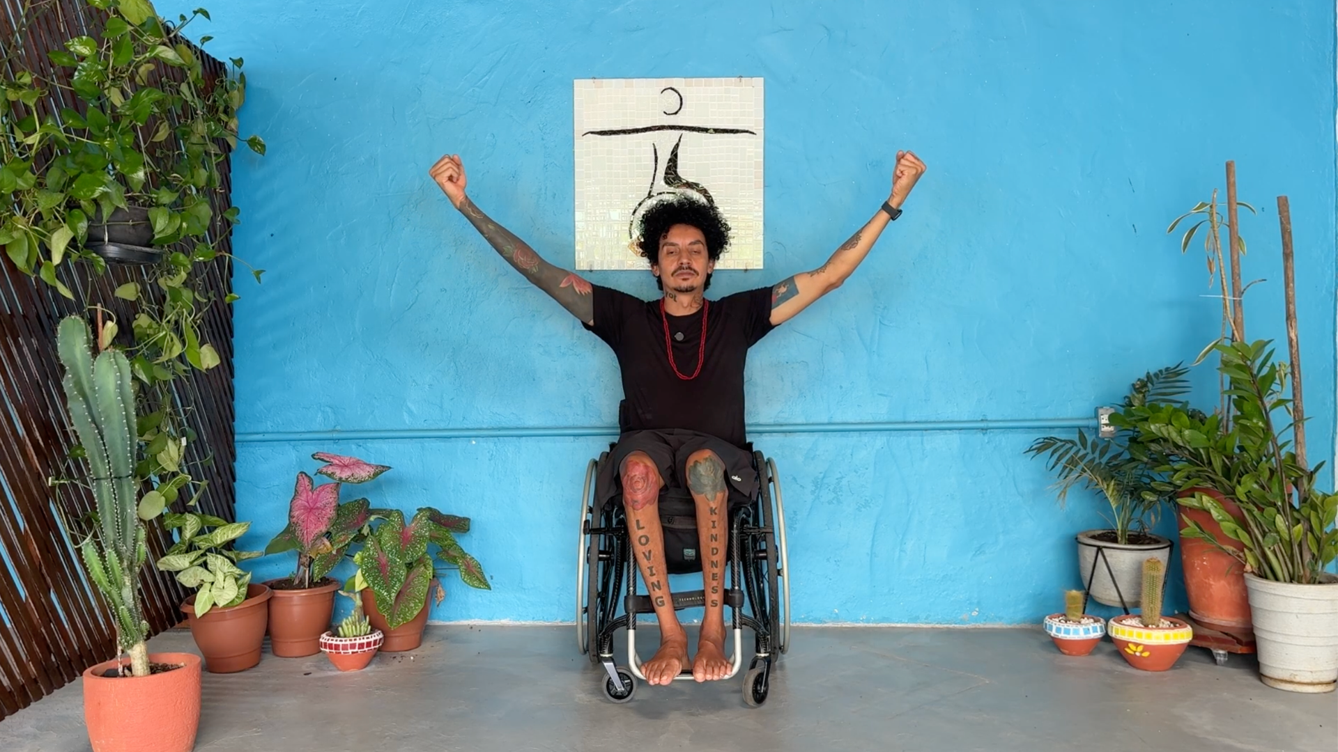 Man seated in a wheelchair lifting his arms and practicing wrist circles