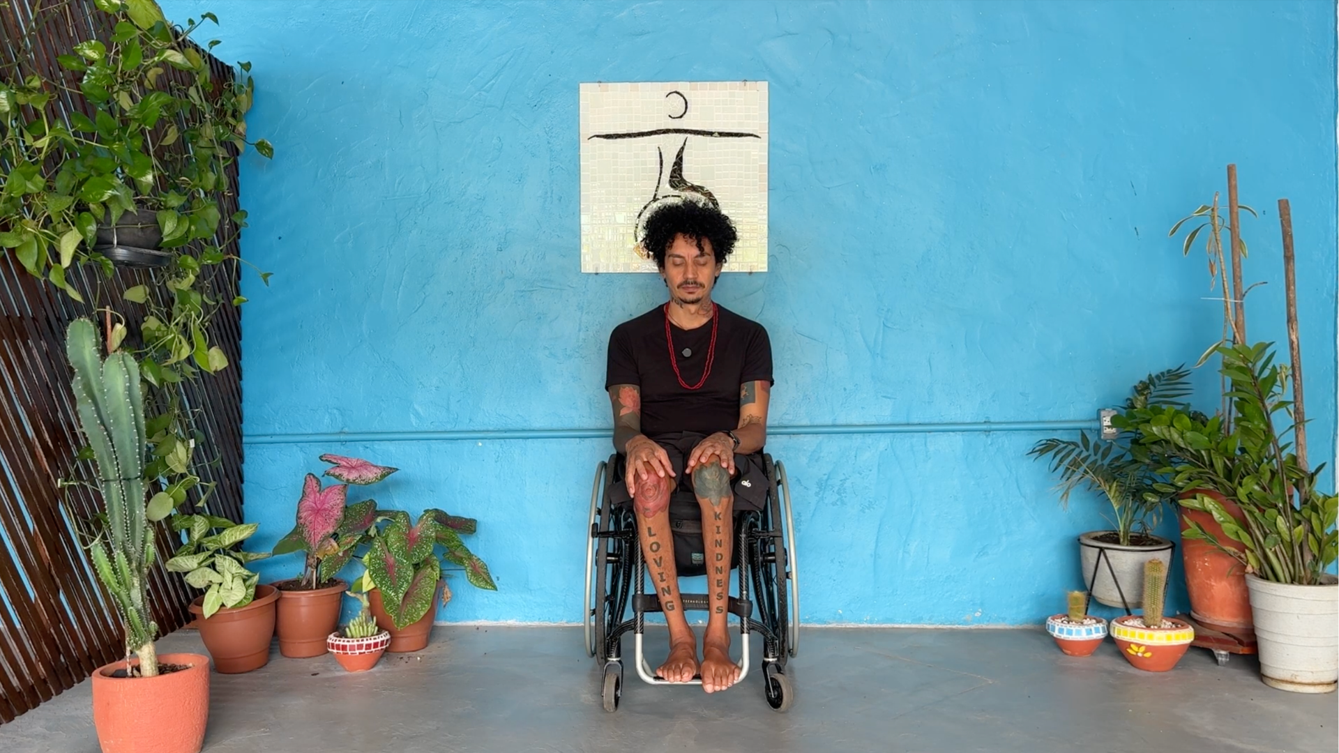 Yoga teacher in wheelchair with hands on thighs yoga teaching chair