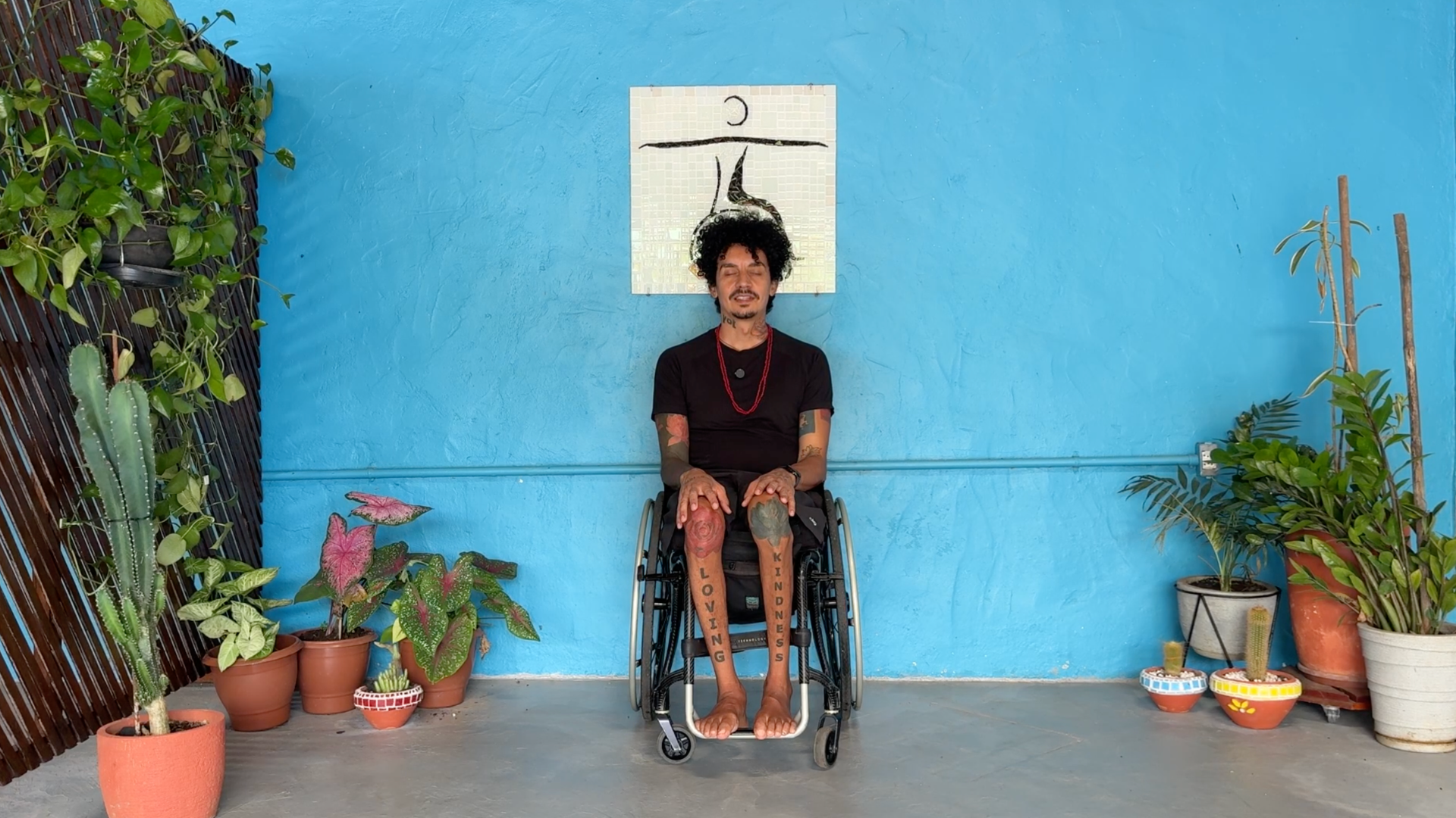 Man sitting in a chair with his palms on his thighs in a seated version of the yoga pose known as Mountain Pose or Tadasana