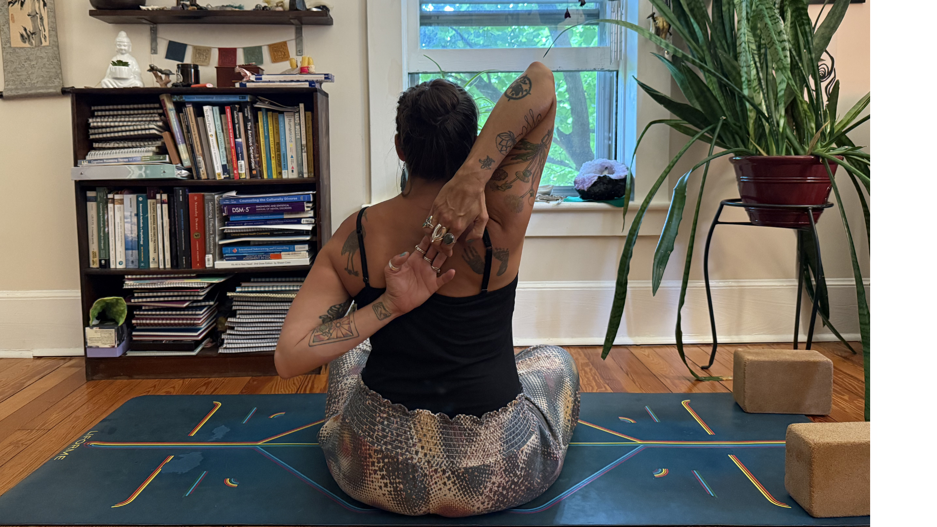 Woman sitting facing away from the camera with her arms reaching behind her back