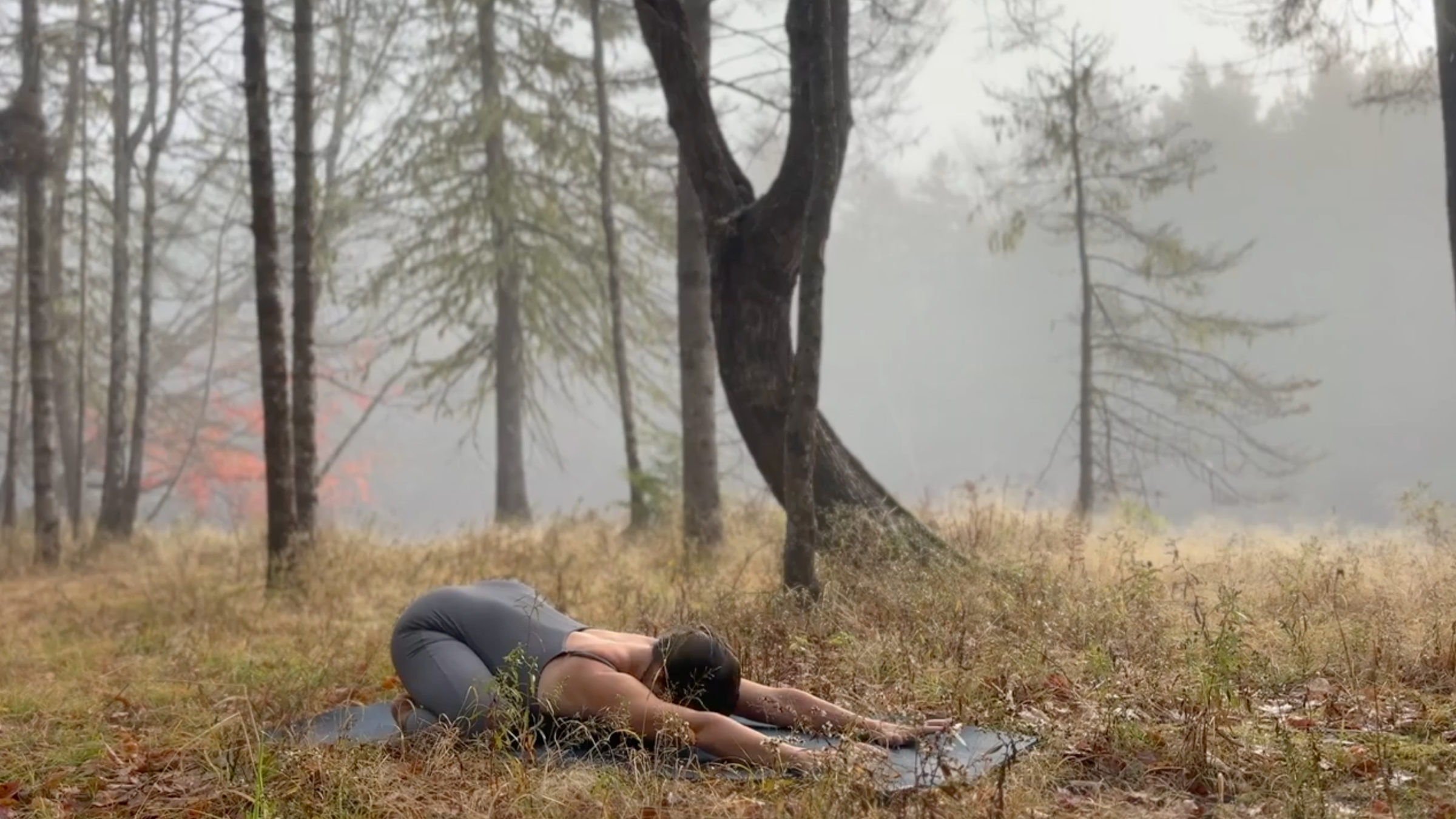 Teacher Emily Baltzer poses in child's pose, part of her gentle morning yoga routine