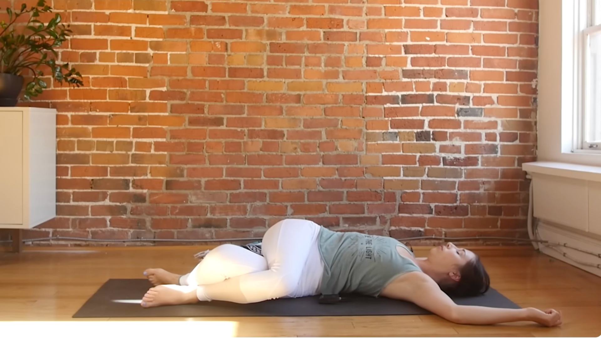 Woman in a reclined spinal twist during a yin yoga for beginners practice