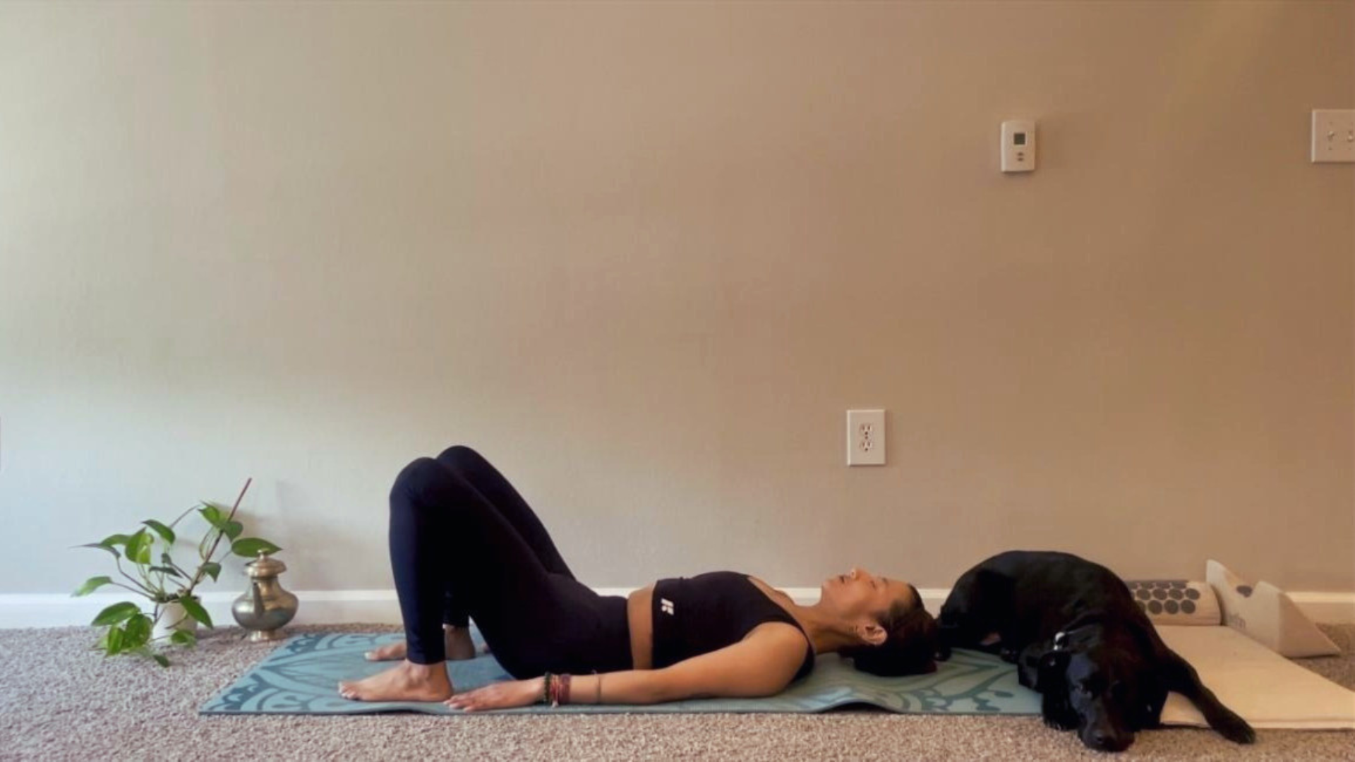 Woman lying on a yoga mat stretching and practicing yoga for lower back pain relief